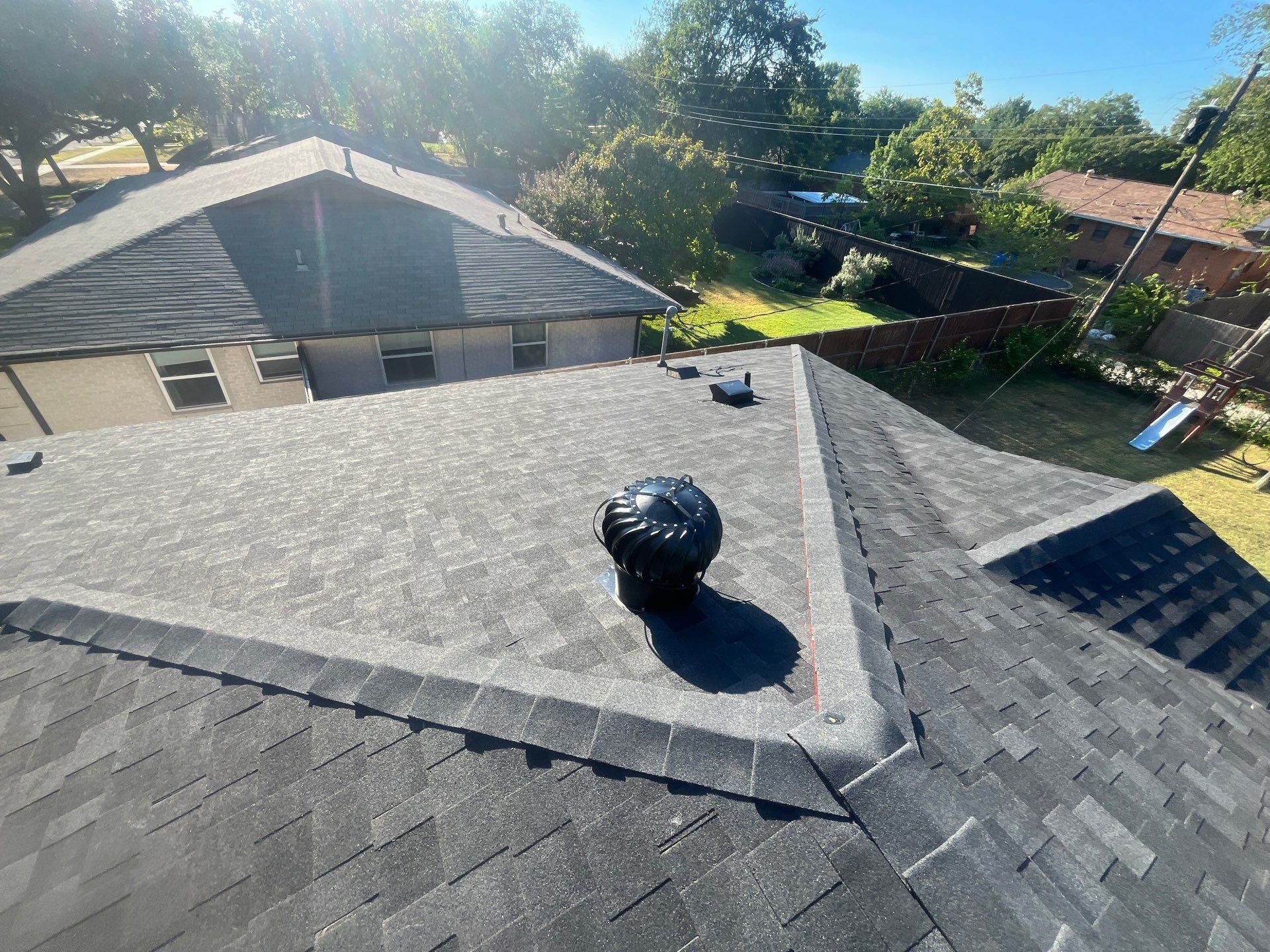White brick/light gray shutters with IKO Granite Black  by Tejas Roofworks + Restoration