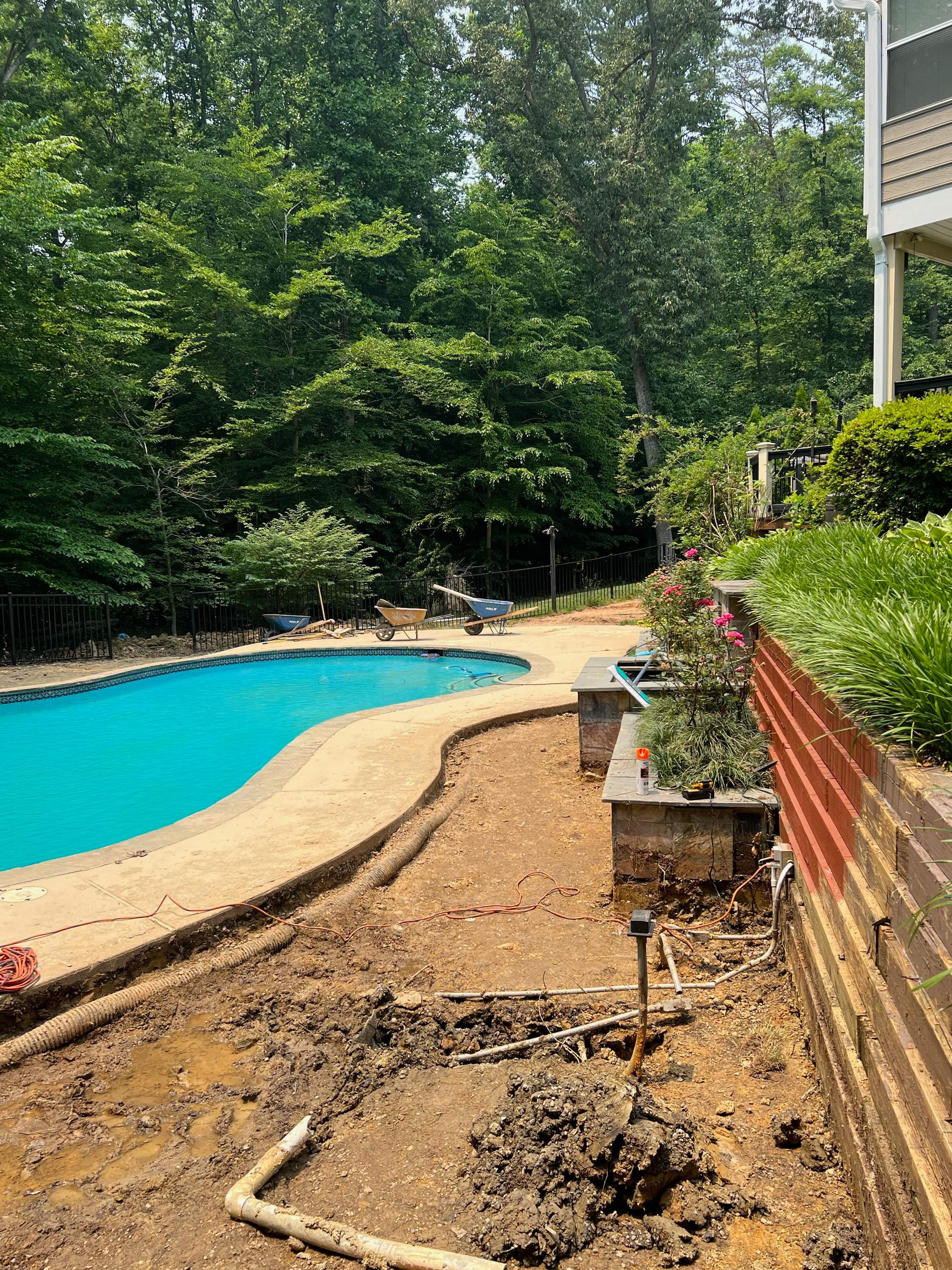 Pool Surround remodel with retaining walls, new waterfall and water slide by Fairfax Contractors, LLC