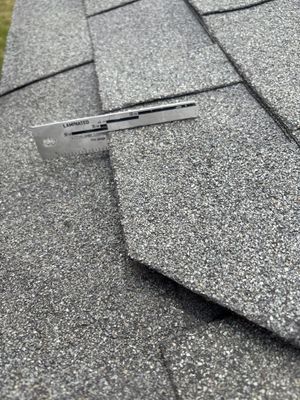 Measuring tool on an architectural asphalt shingle roof.