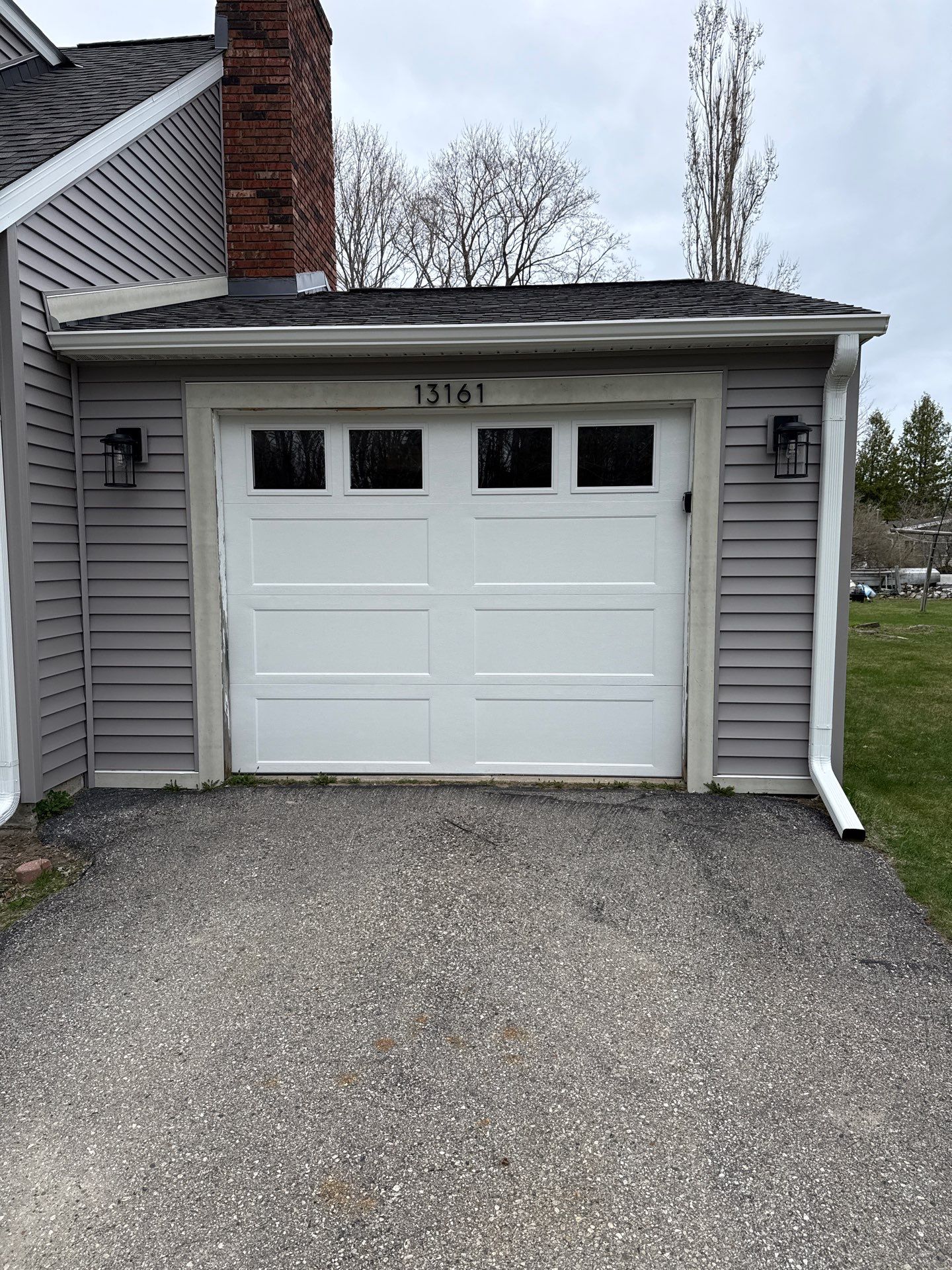 White Seamless Gutter and Downspout Installation in Charlevoix by Rainbow Seamless Systems