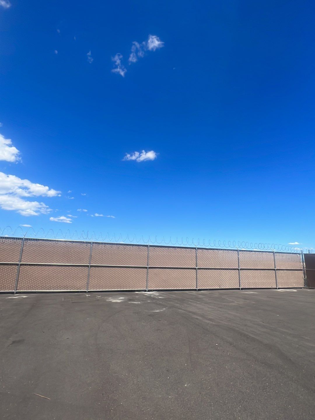 Commercial       using 8'+1' 9ga chain link with slats and razor wire by Valley Fence Company