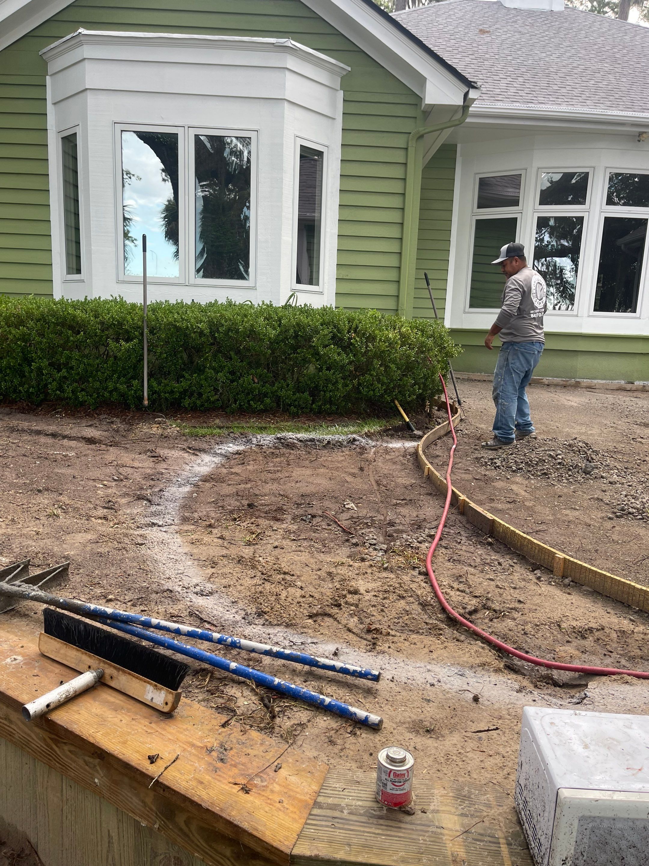 Exposed Aggregate Patio with Brick Inlays and Retaining Wall in Okatie by Lowcountry Scapes, LLC
