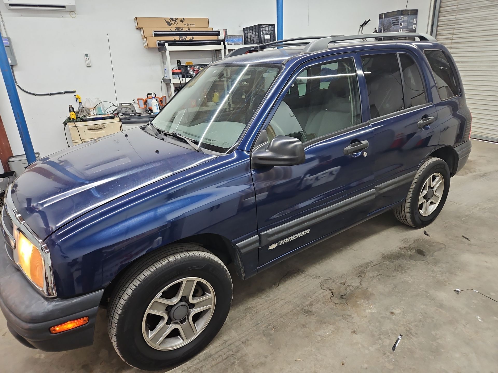 the image shows a vehicle undergoing window tinting service by a professional company the car is a compact suv with a dark blue exterior the technicians are likely applying a translucent film to the windows this service is intended to reduce glare enhance privacy and improve the overall appearance of the vehicle the interior is protected while also providing a sleek look to the car the work area appears organized indicating a careful approach to the service being performed