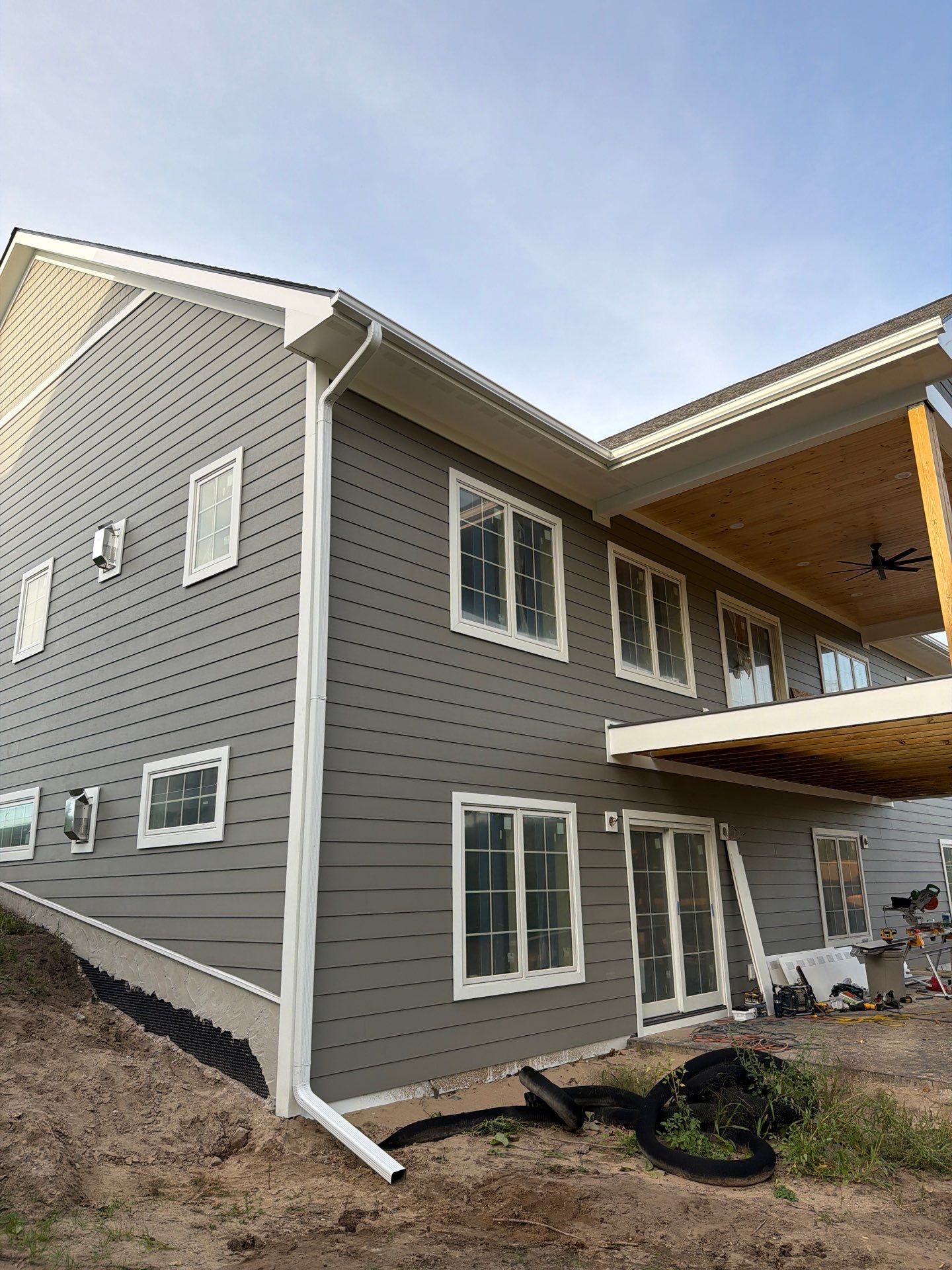 White Gutter and Downspout Installation for Petoskey New Build by Rainbow Seamless Systems
