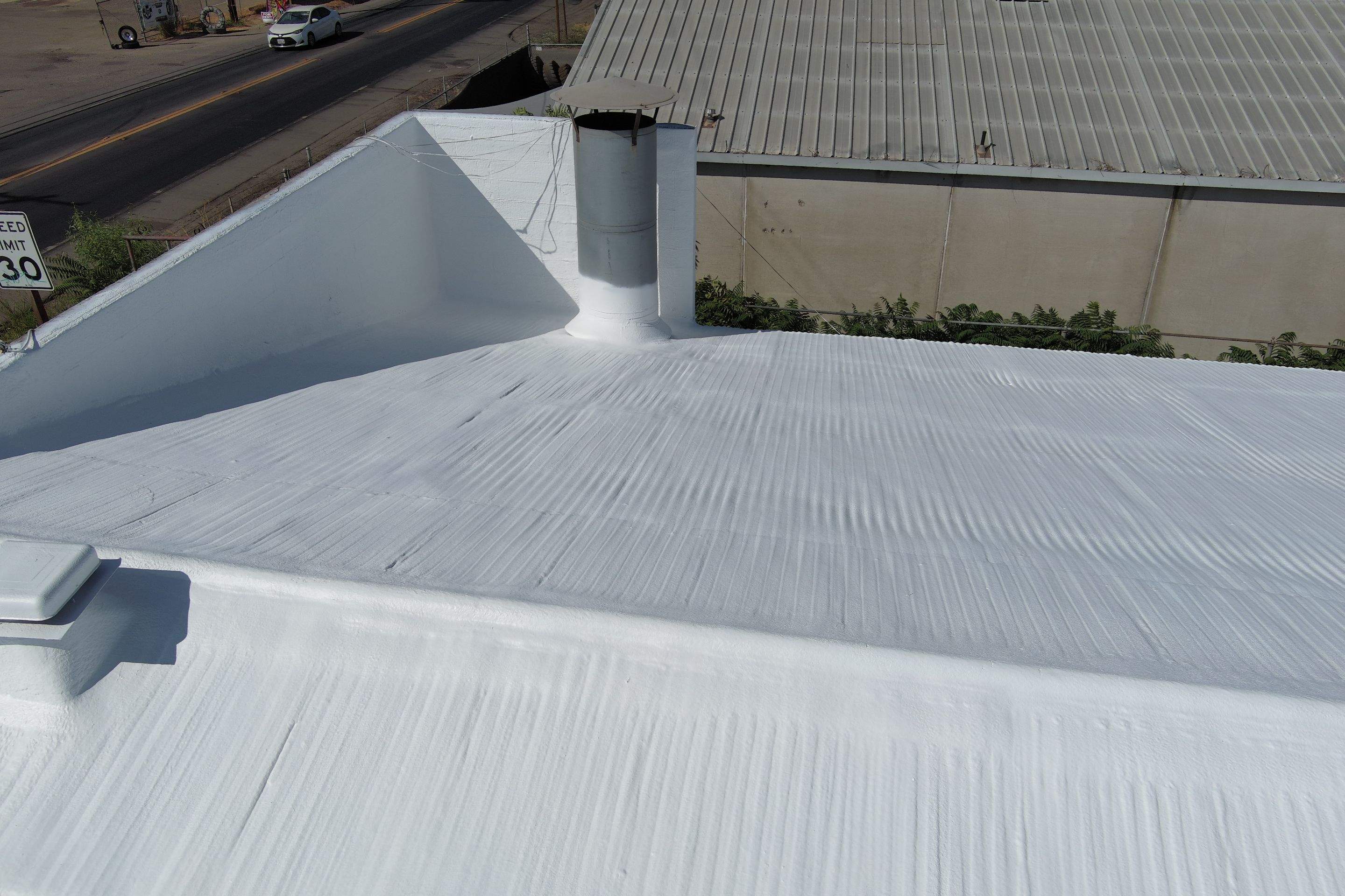 Spray foam and coatings using Conklin Benchmark/ PUMA XL acrylic coatings over metal and foam by Straight Edge Roofing Inc