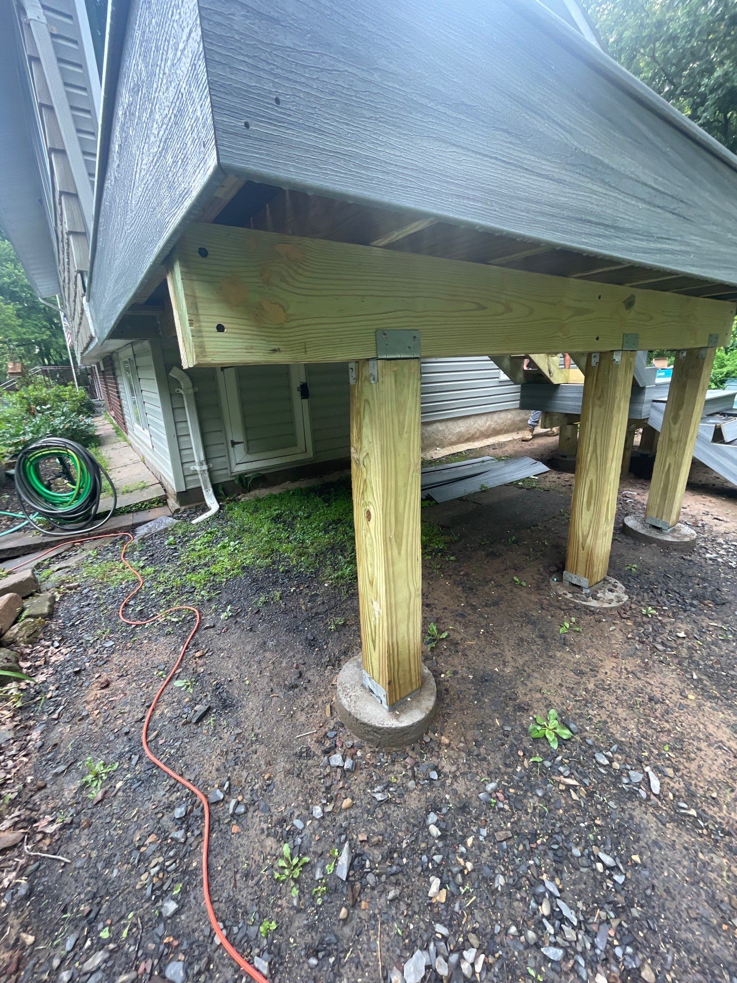 Raised Gray Composite Deck and Staircase Construction in Pocono Summit, PA by Herts Roofing & Construction