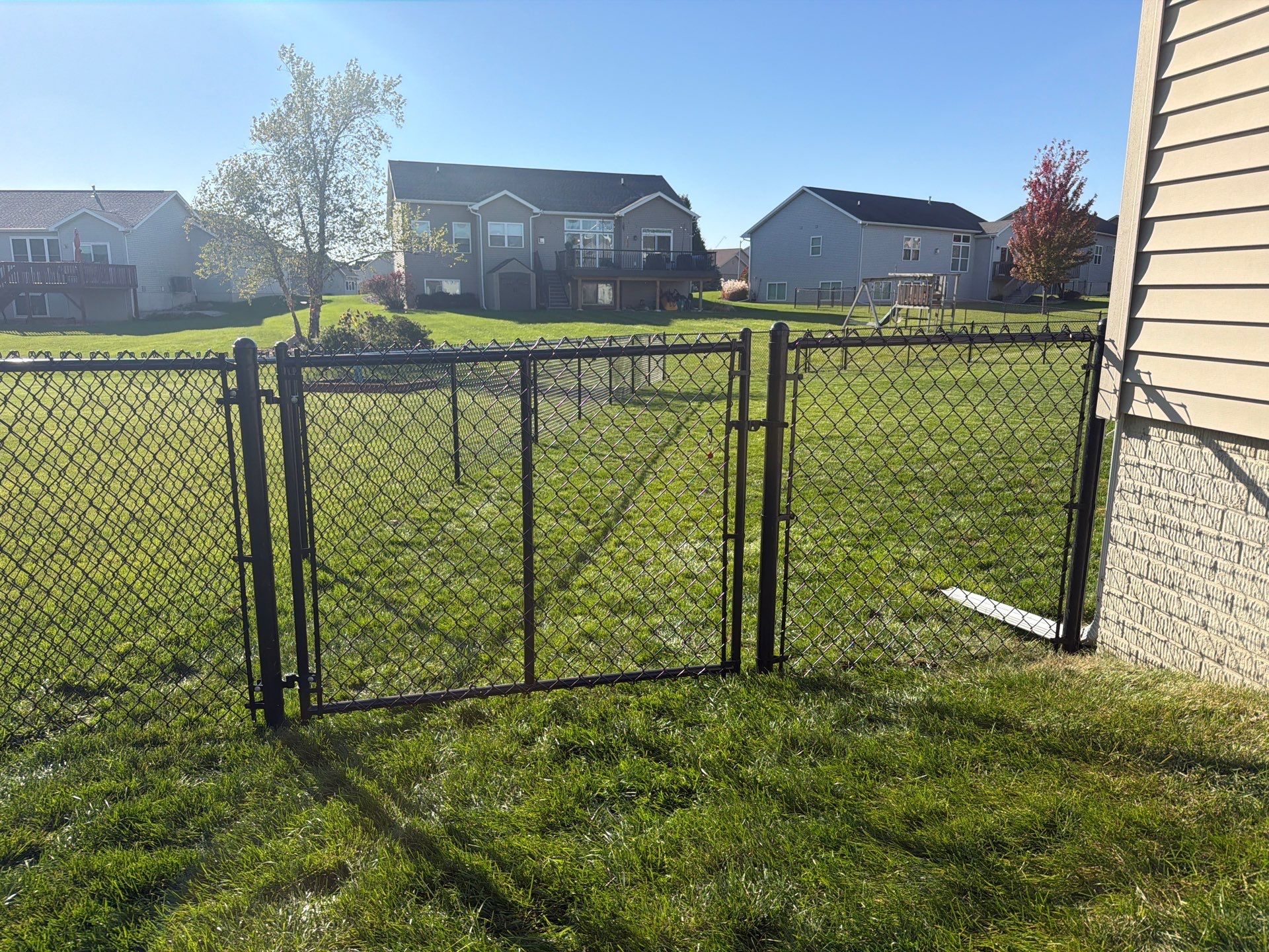 Black Vinyl-Coated Chain Link Fence Installation in Cedar Falls by Perfect Picket Fence and Stain