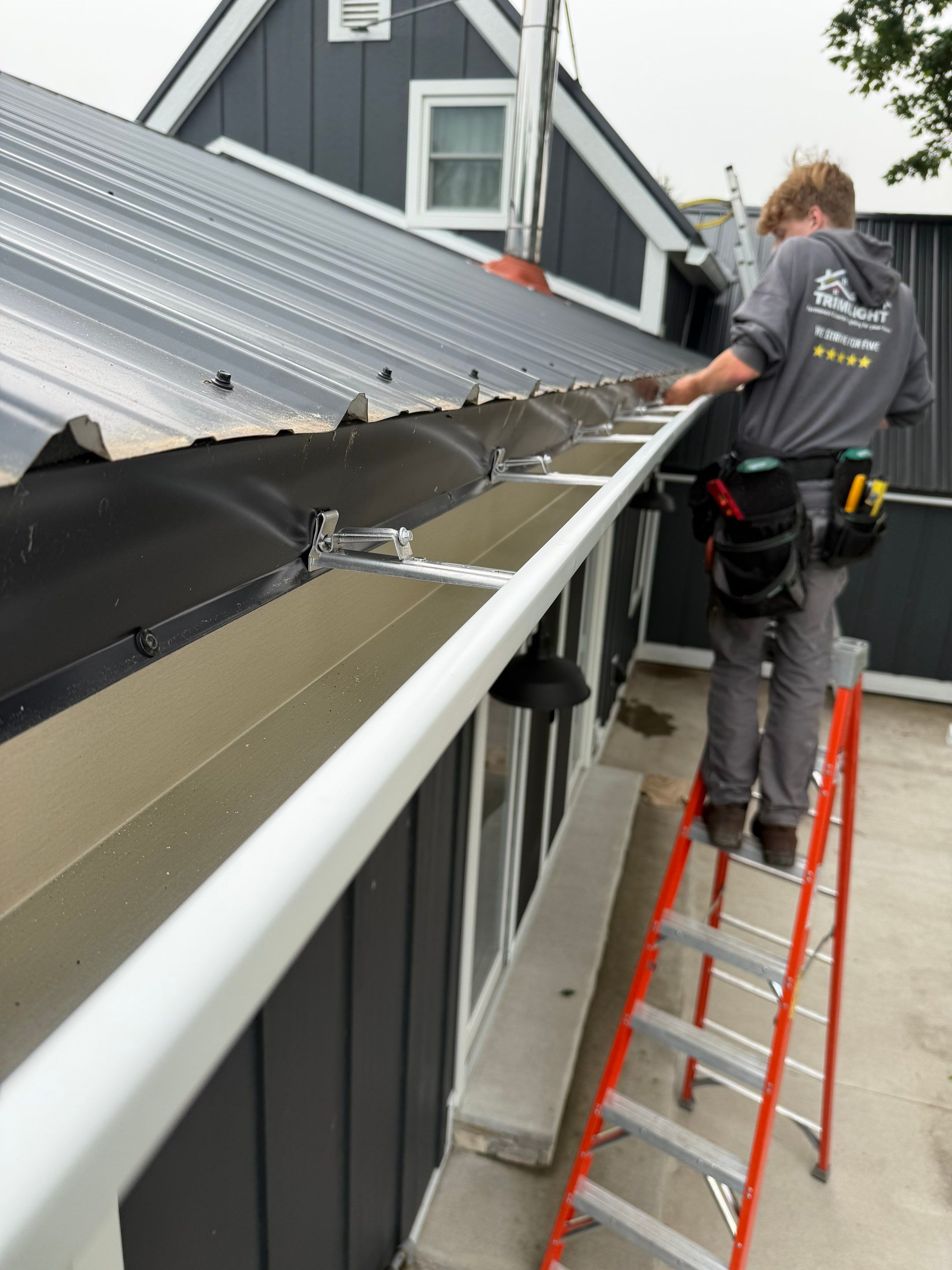 Seamless Gutter and Gutter Helmet Installation on Bellaire Metal Roof by Rainbow Seamless Systems