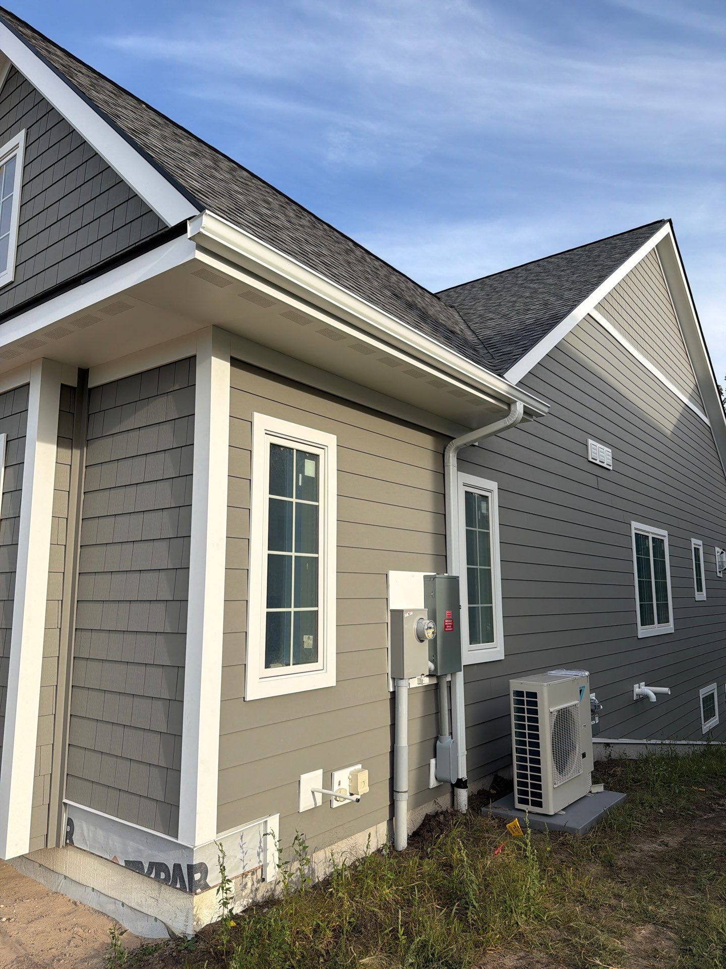 White Gutter and Downspout Installation for Petoskey New Build by Rainbow Seamless Systems