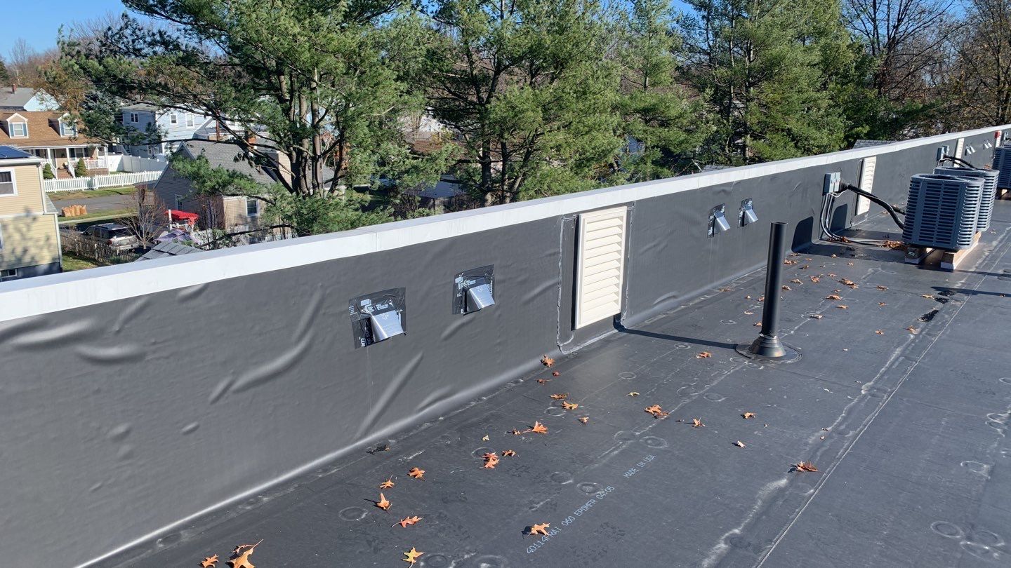 Commercial Roofing Installation using EPDM with white gutters by A Plus Exterior