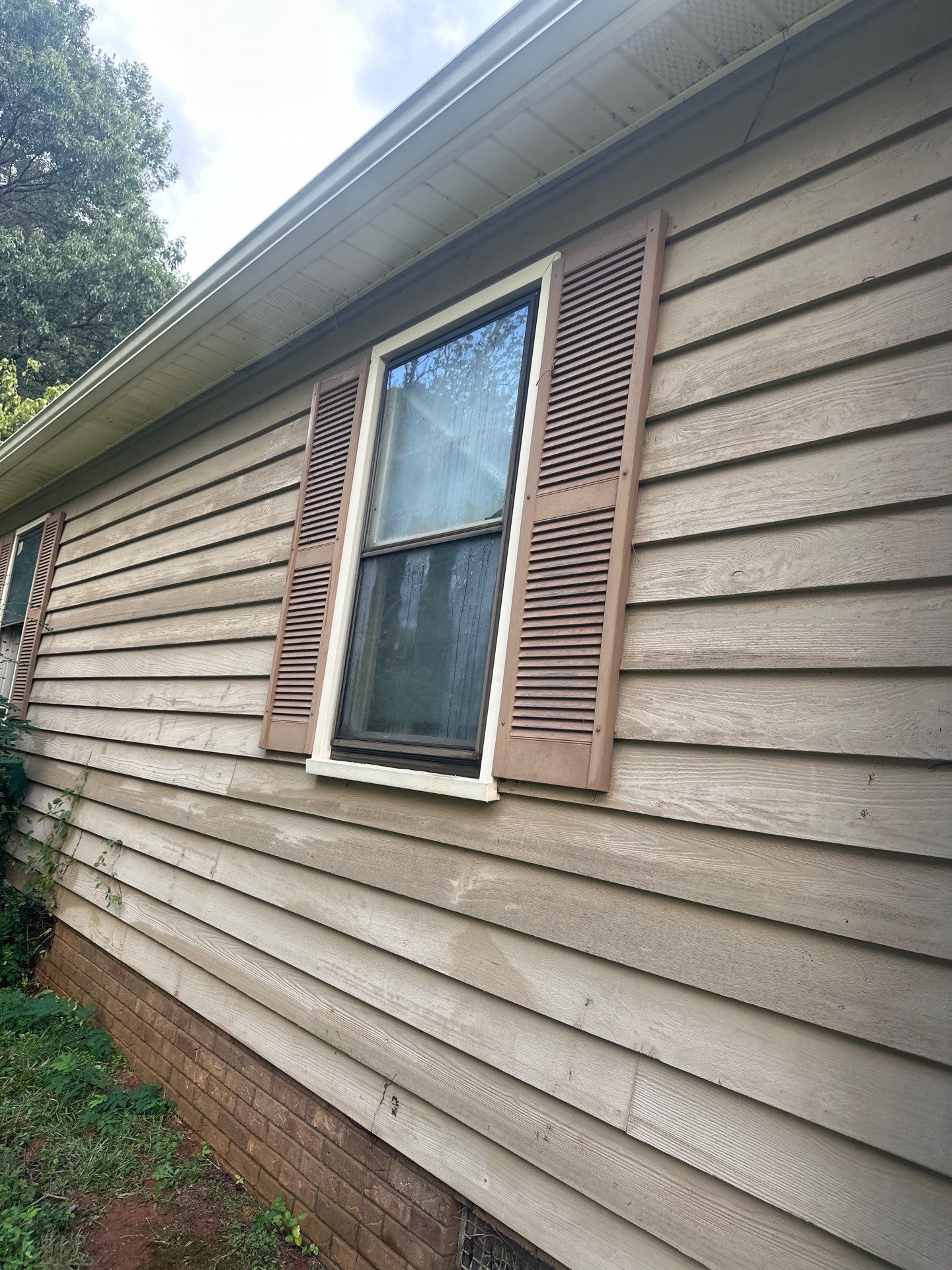 cleaning of house siding and window surfaces using pressure washing techniques to remove dirt and grime