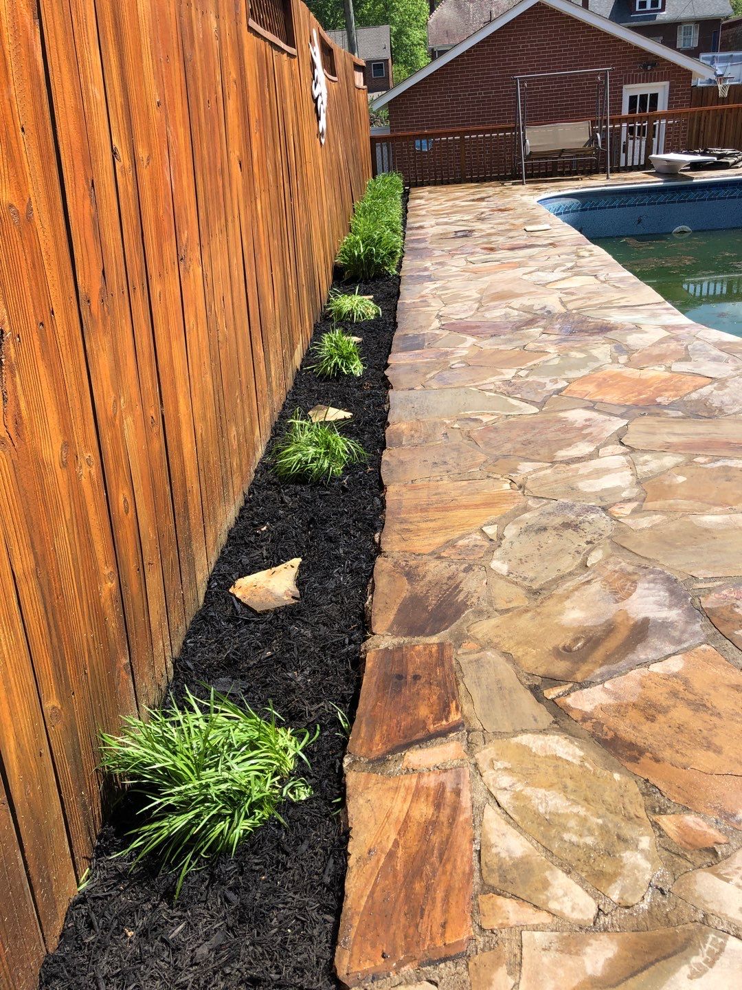 Liriope grasses, mulch and stone pavers by GrassBusters, Inc.