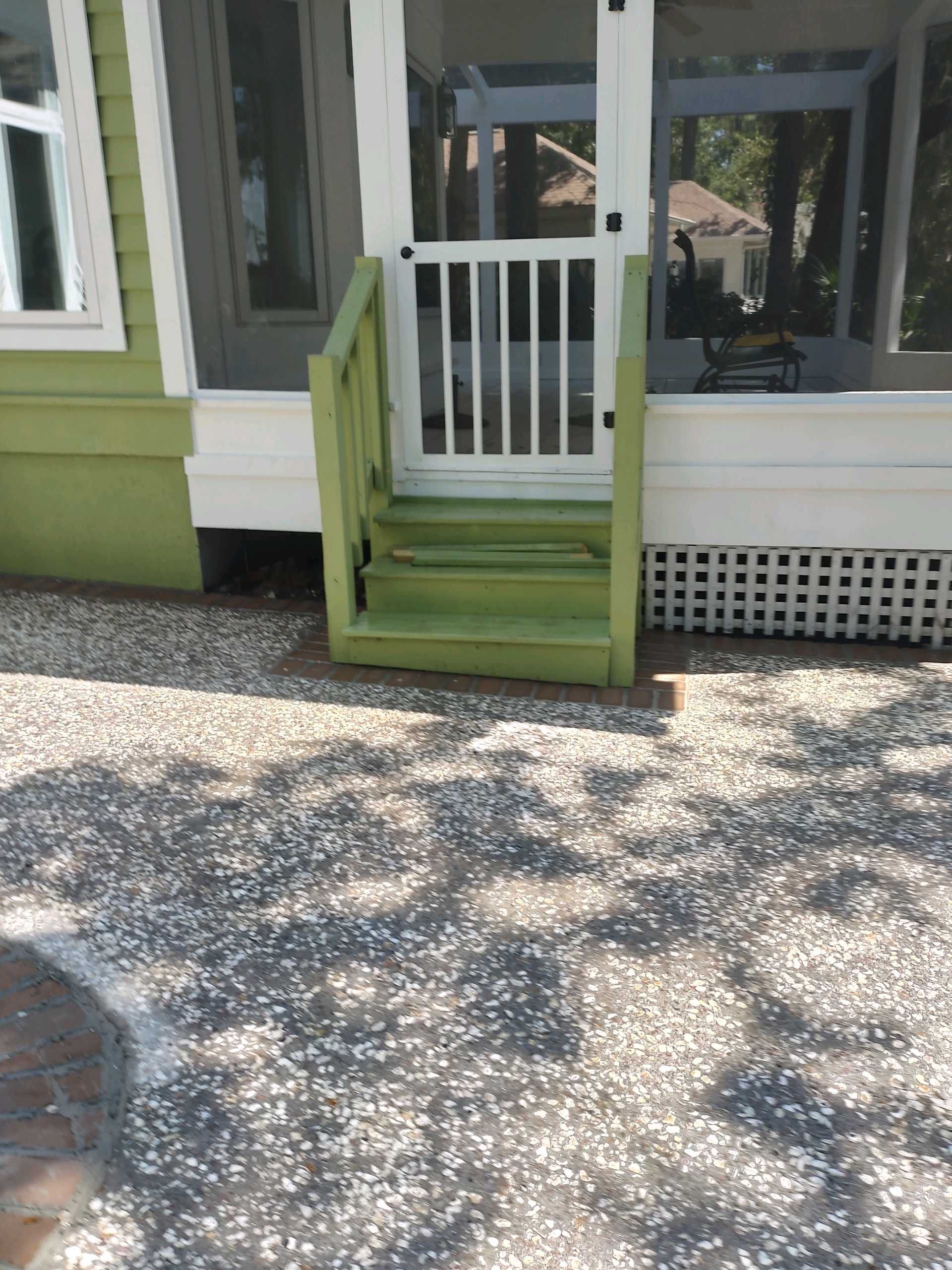 Exposed Aggregate Patio with Brick Inlays and Retaining Wall in Okatie by Lowcountry Scapes, LLC