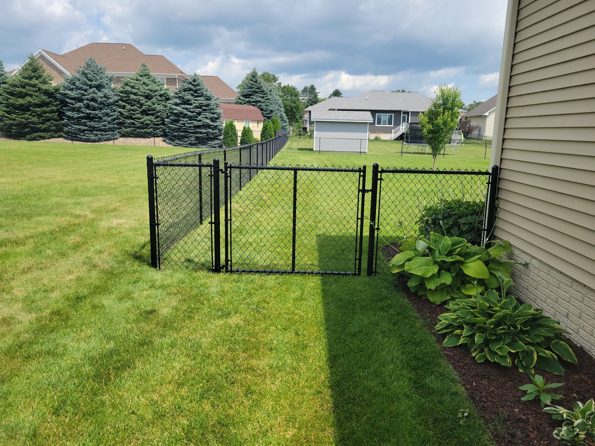 Black Vinyl Coated Chain Link Fence Installation in Cedar Falls by Perfect Picket Fence and Stain