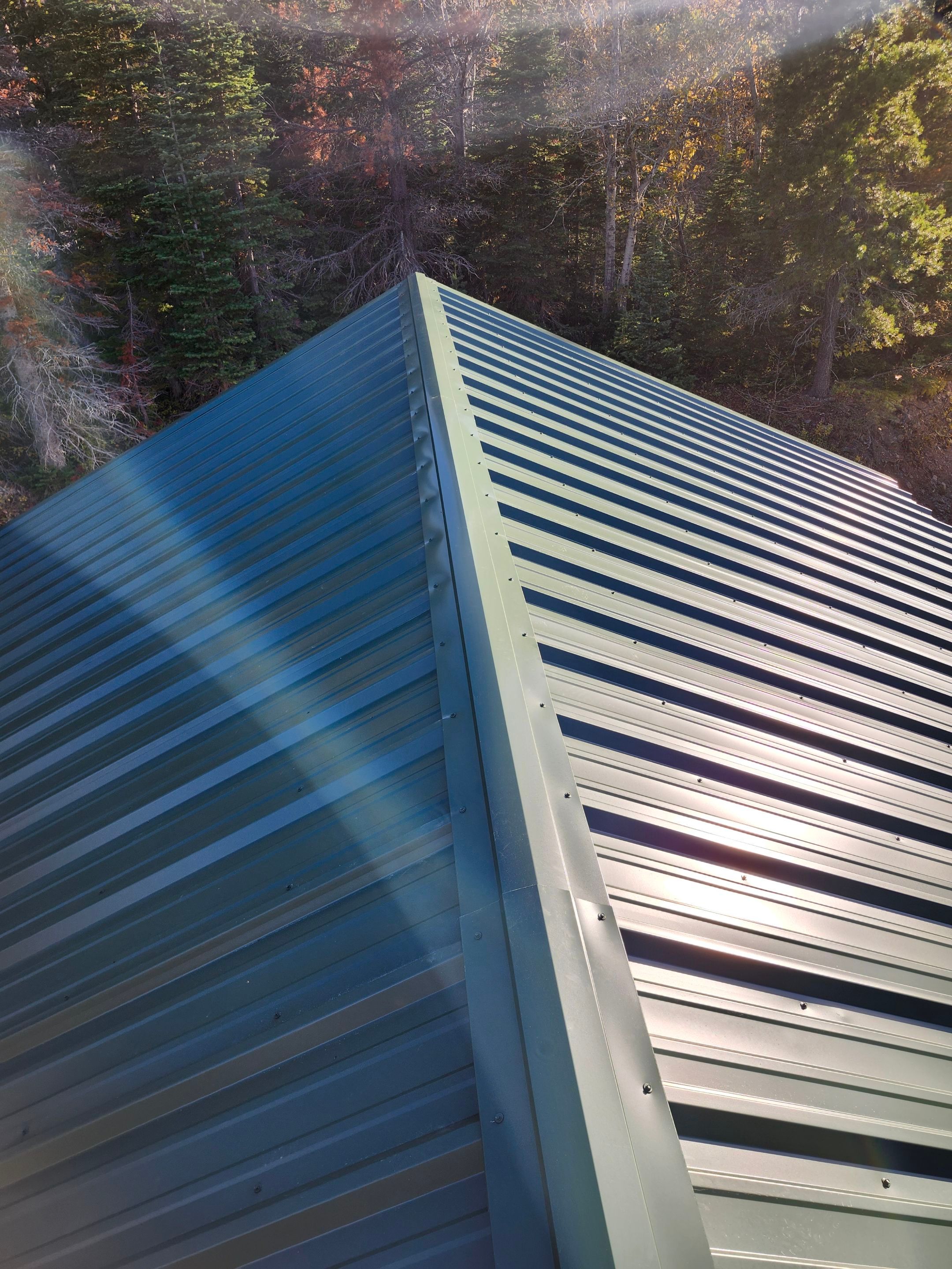 Green Standing Seam Metal Roof Installation in East Glacier Park by KQC Roofing
