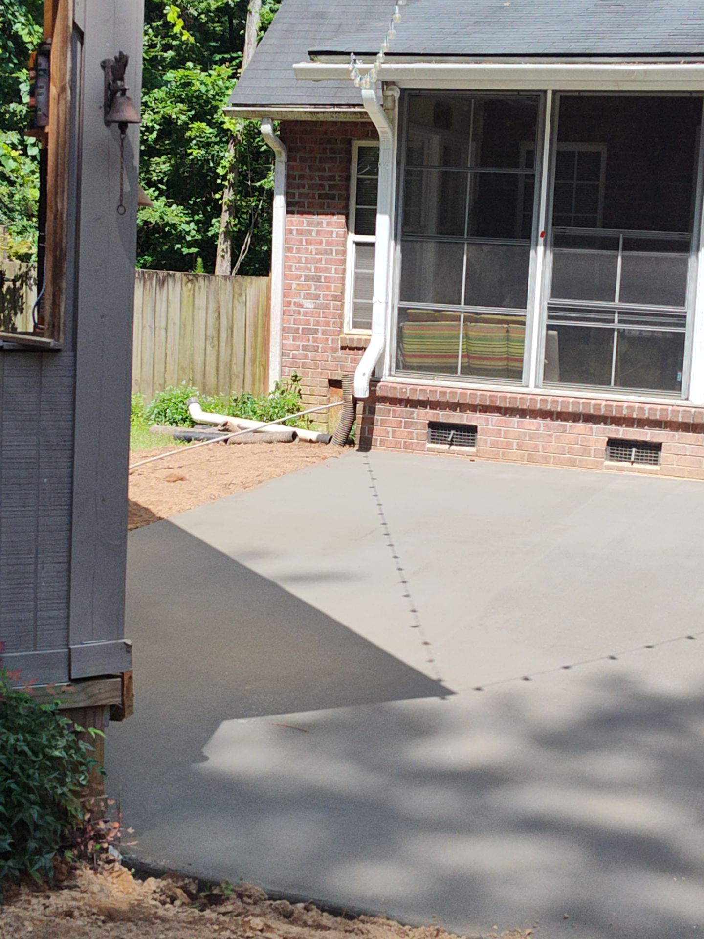 Patio in concrete with drainage improvements by Cornerstone Home Builders, LLC