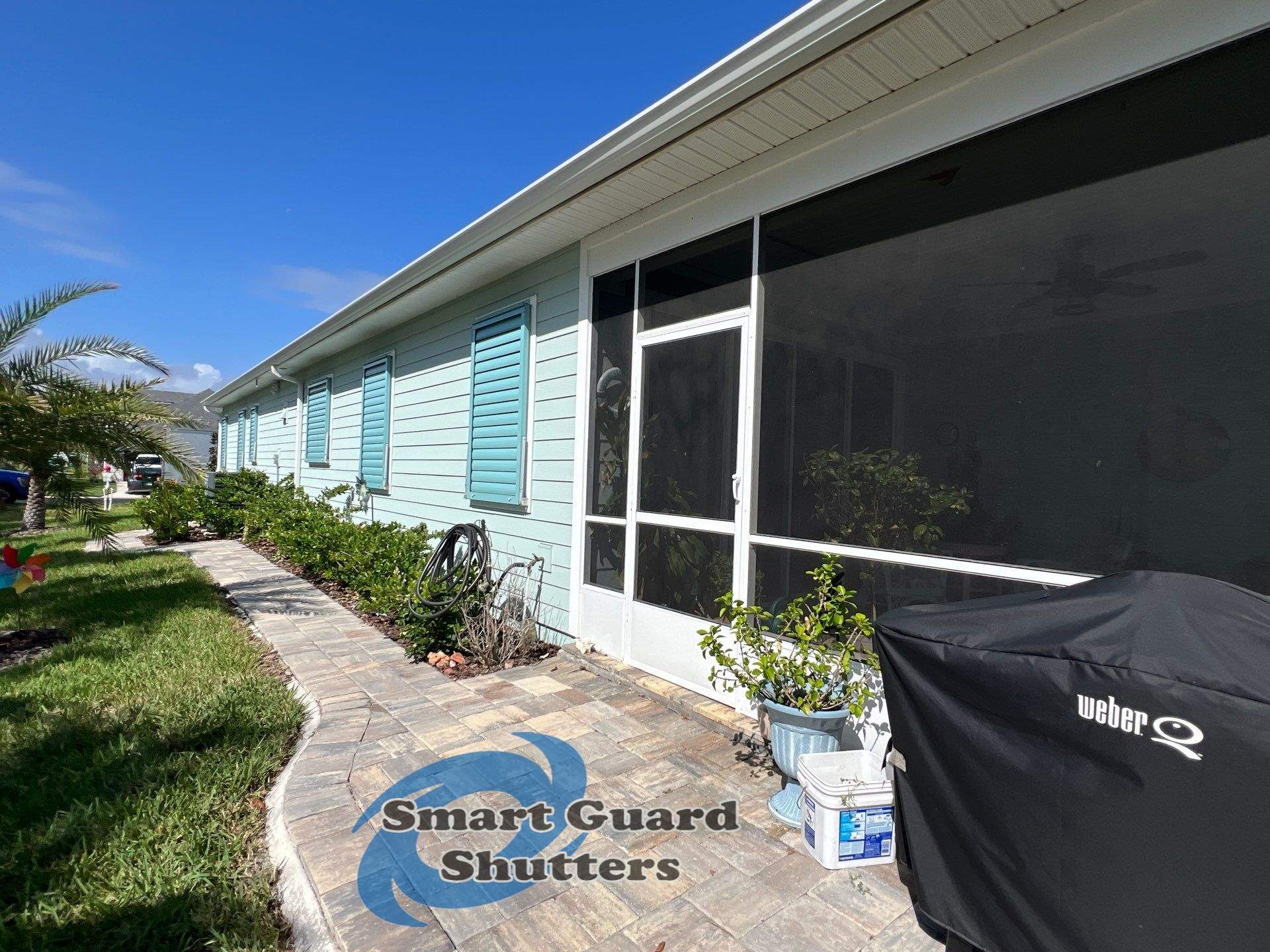 Impact Bahama Shutters in Pastel Turquoise by Smart Guard Shutters