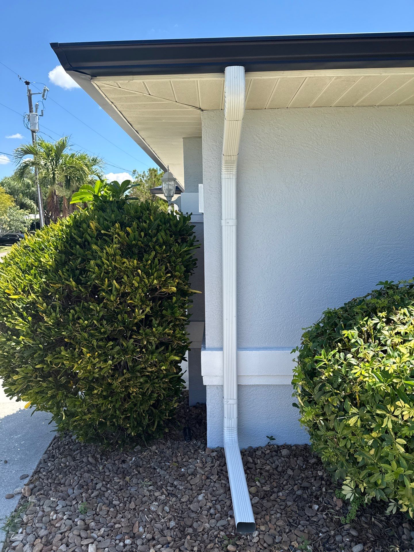 Black Seamless Gutters and White Downspouts in Cape Coral FL by Gutter Professors
