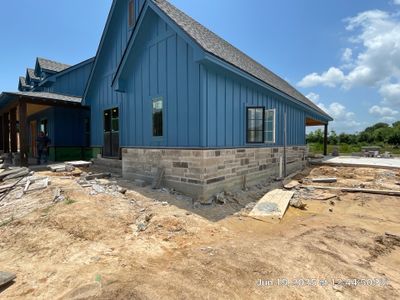 Natural Stone Elegance: Apex Installation Accented by Blue Siding