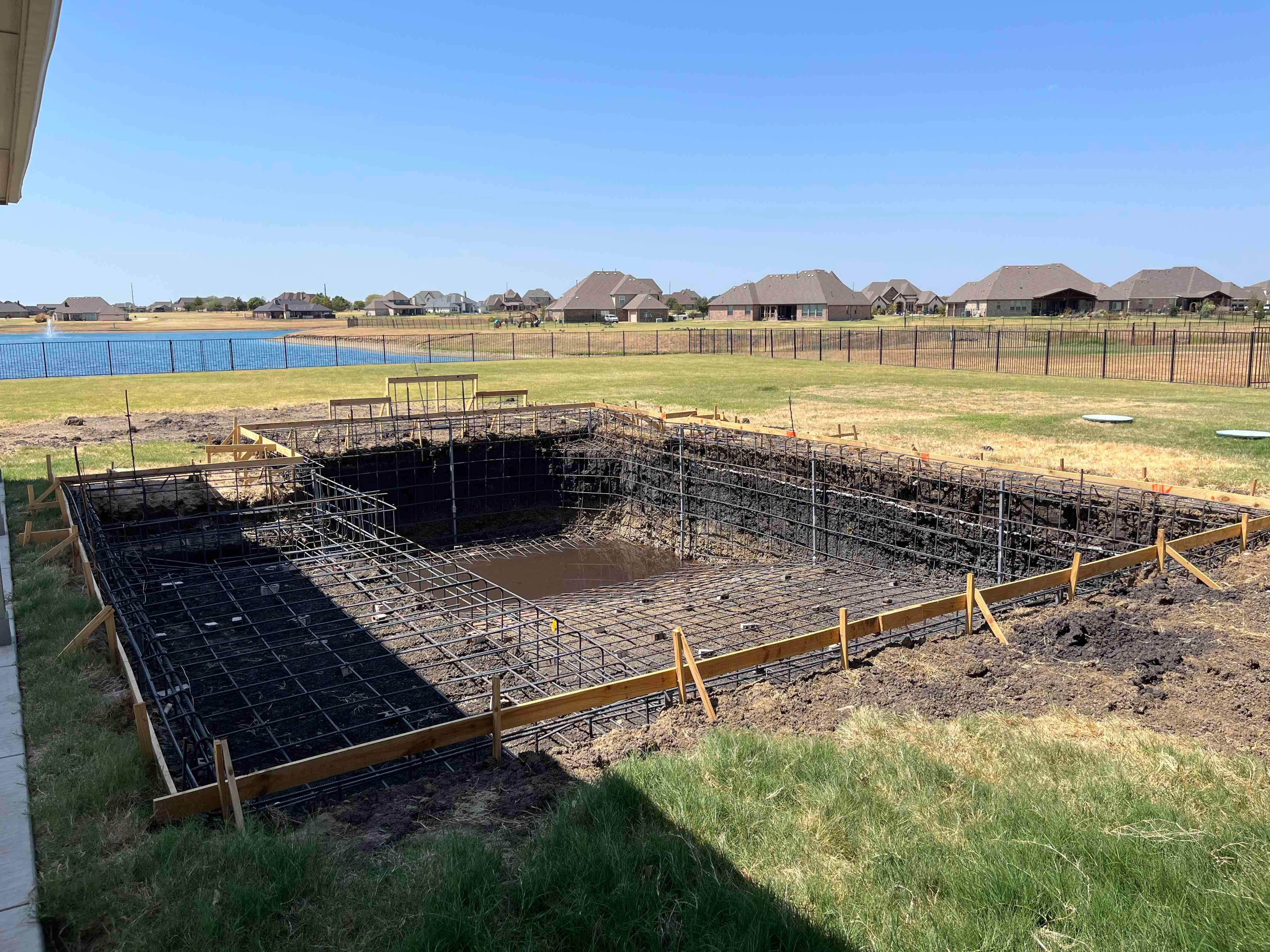 Modern Lakefront Pool with Raised Spa and Dark Interior by Pinnacle Pools and Spas - DFW
