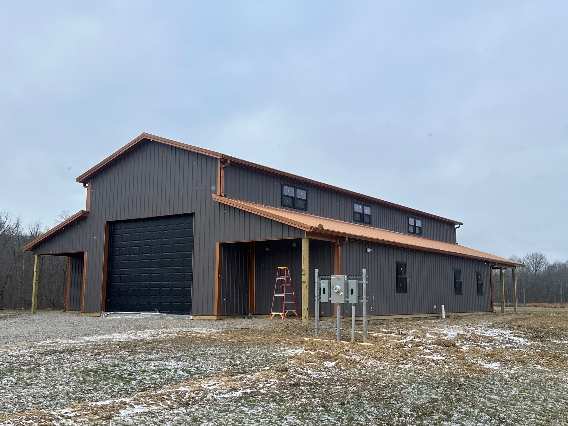 Custom Pole Barn Home with Charcoal Siding and Copper Roof by The Barn Builders