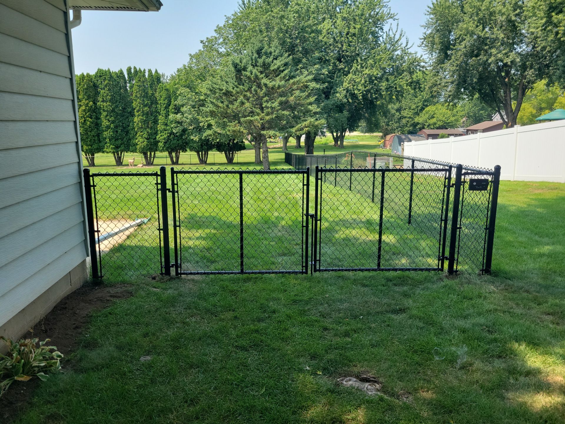 Black Vinyl-Coated Chain Link Fence Installation in New Hampton by Perfect Picket Fence and Stain