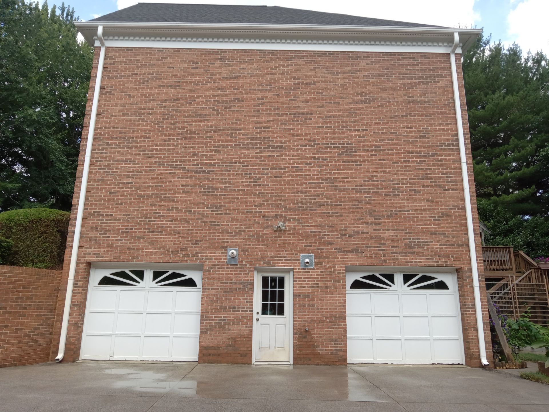 pressure washing of driveway concrete garage doors brickwork exterior walls to remove dirt grime for cleanliness and maintenance