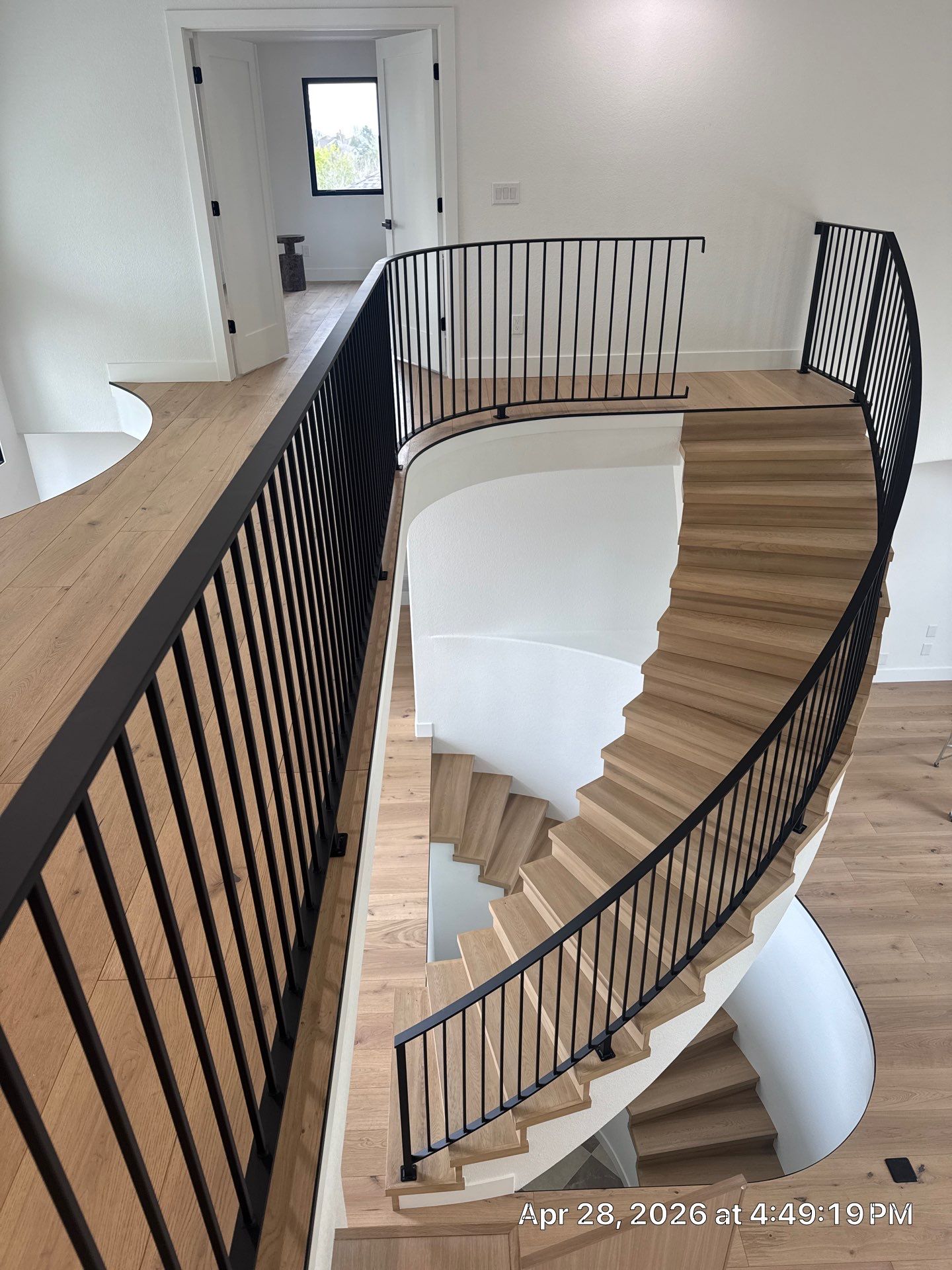 Curved Oak Staircase and Custom Metal Railing Installation in Lone Tree by LP Construction Services