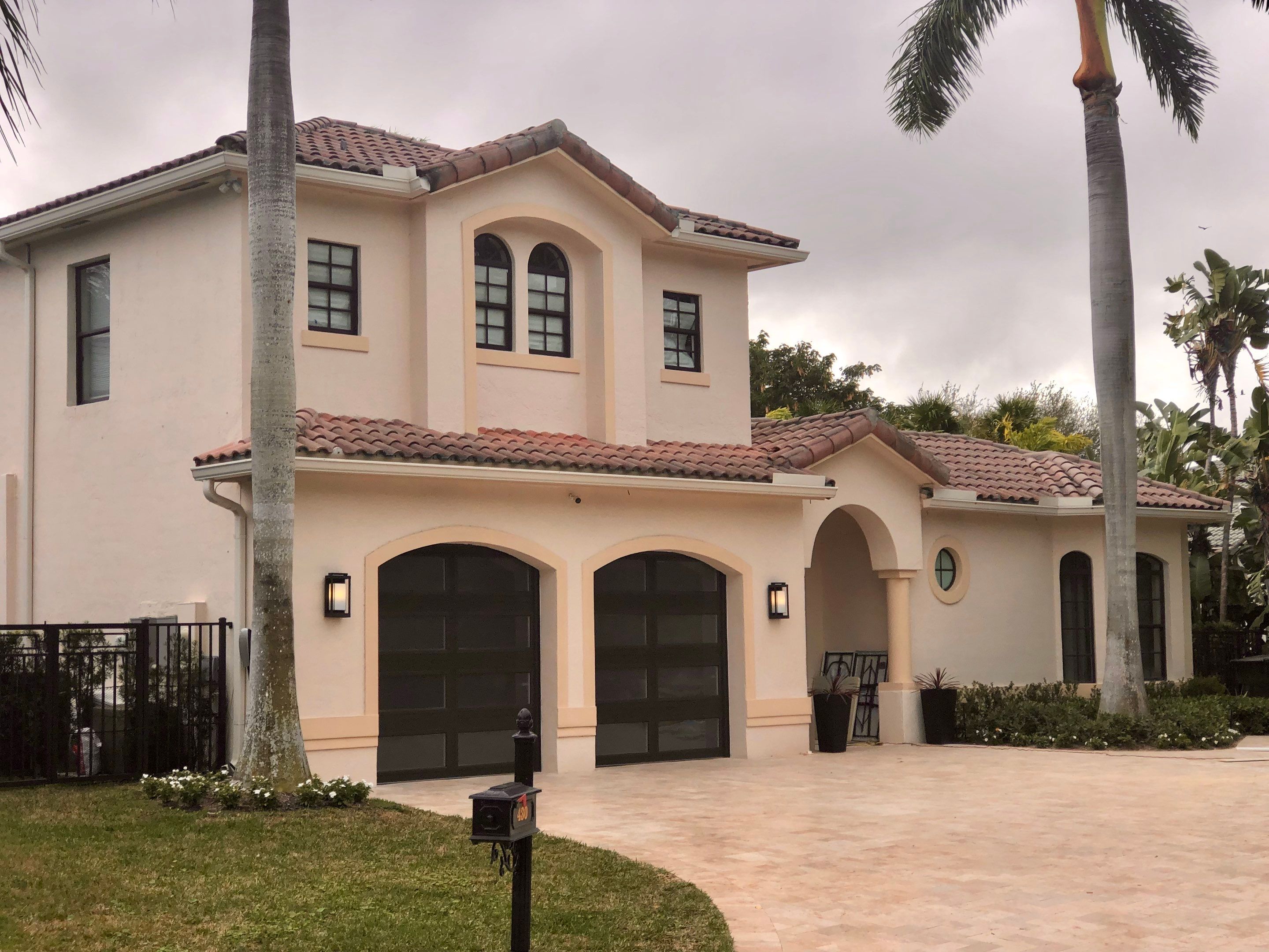 Modern Bronze Garage Door Installation With Frosted Glass in Boca Raton by The Door Doctor of South Florida, Inc.