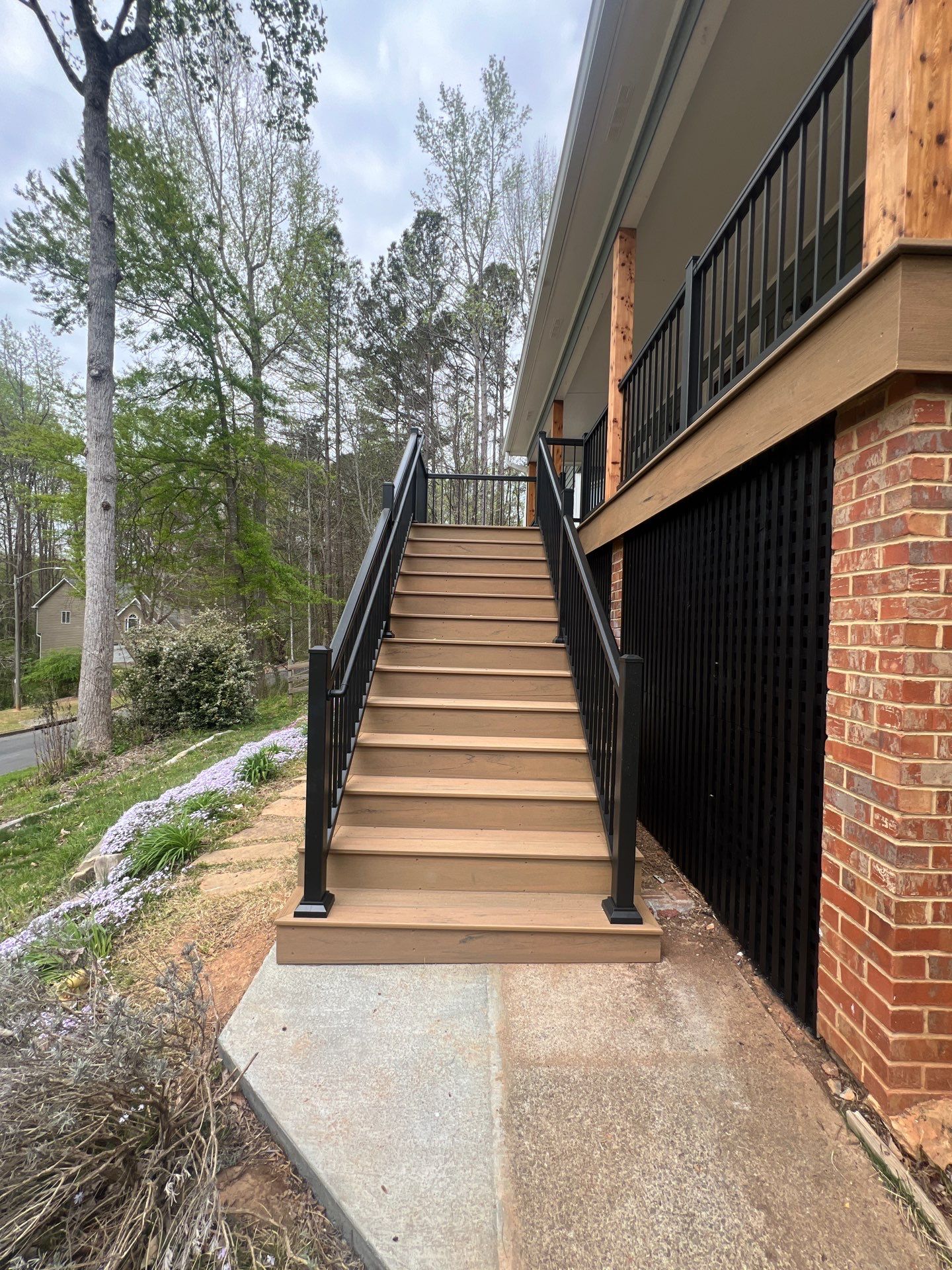 Composite Deck and Porch Renovation With Black Metal Railings by Swift Home Renovations 