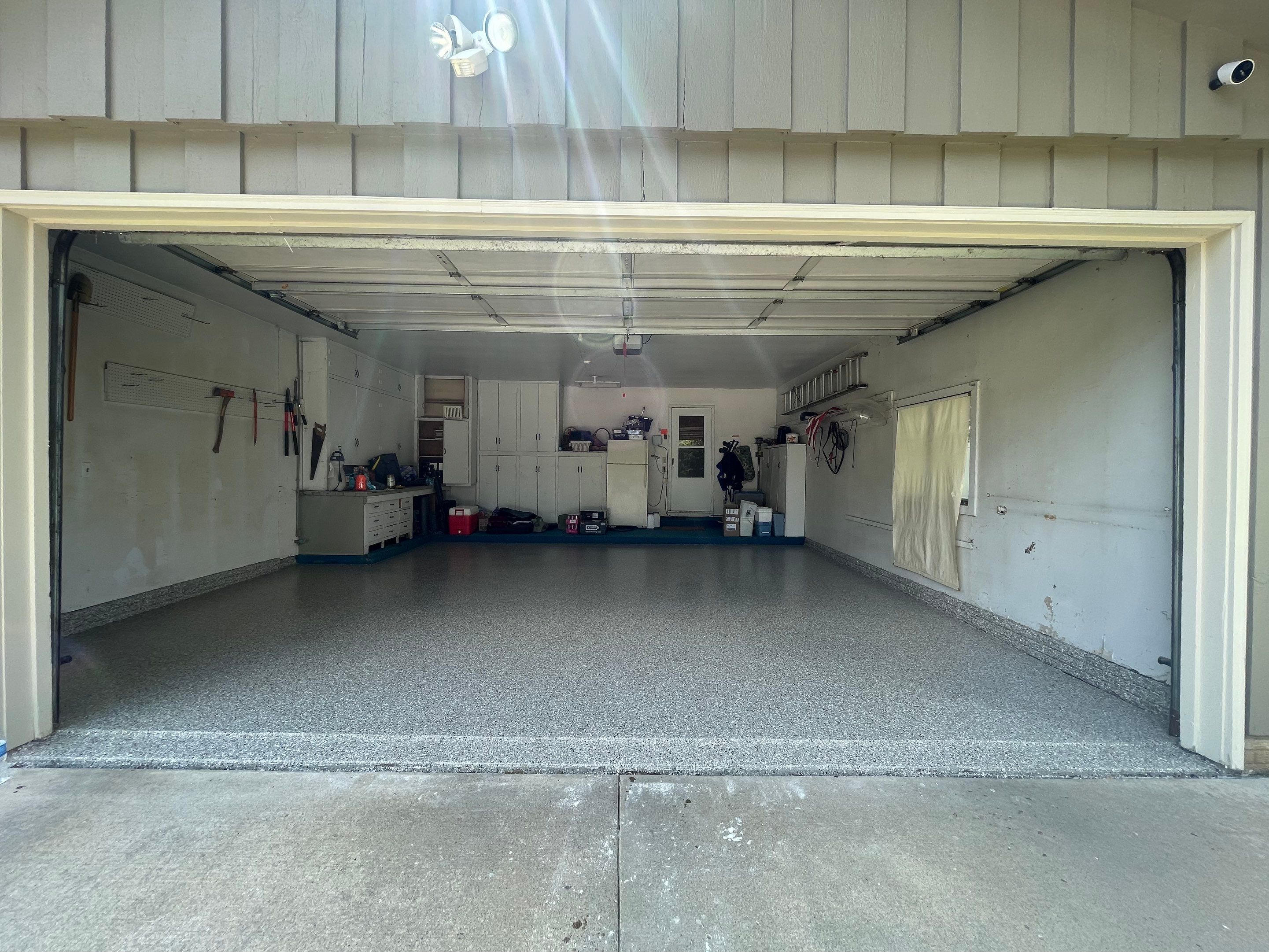 Coyote Flake Garage Floor Coating in Sioux Falls with Trench Drain by Select Painting, Coatings & Garage Cabinets