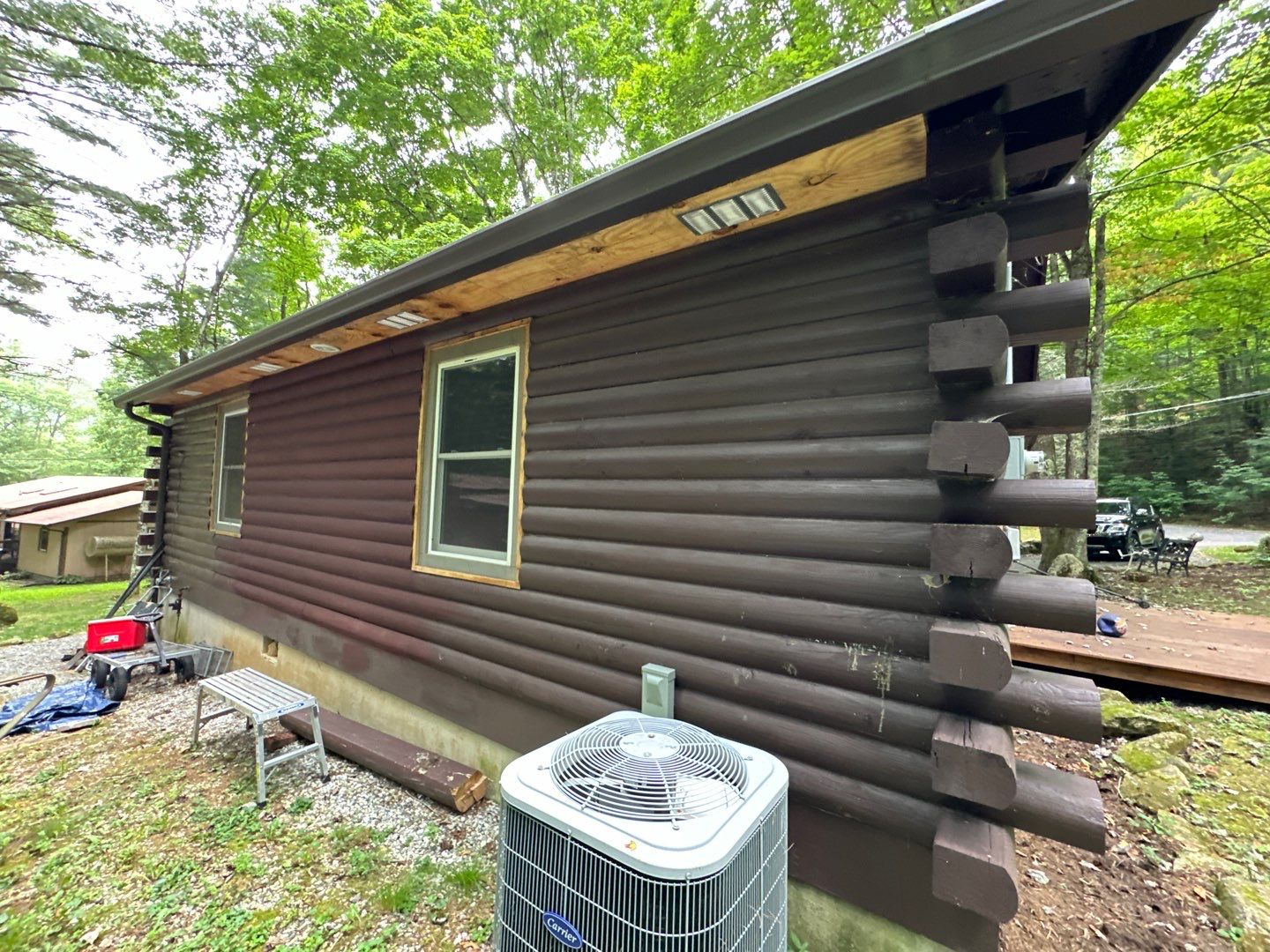 the service shown is cleaning the wooden log siding of a house to remove dirt and grime