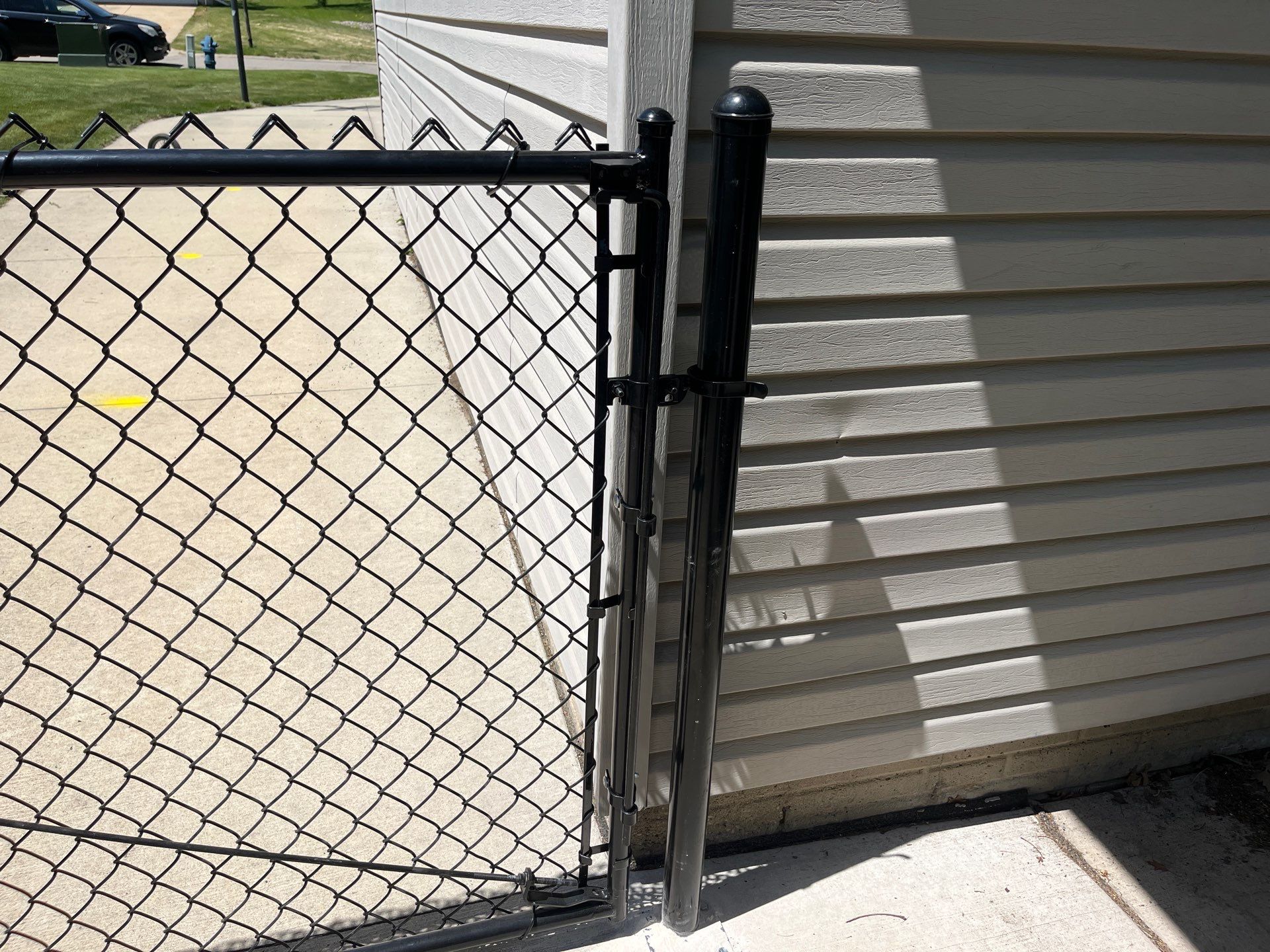 Black Chain Link Fence and Driveway Gate Installation in Waterloo by Perfect Picket Fence and Stain