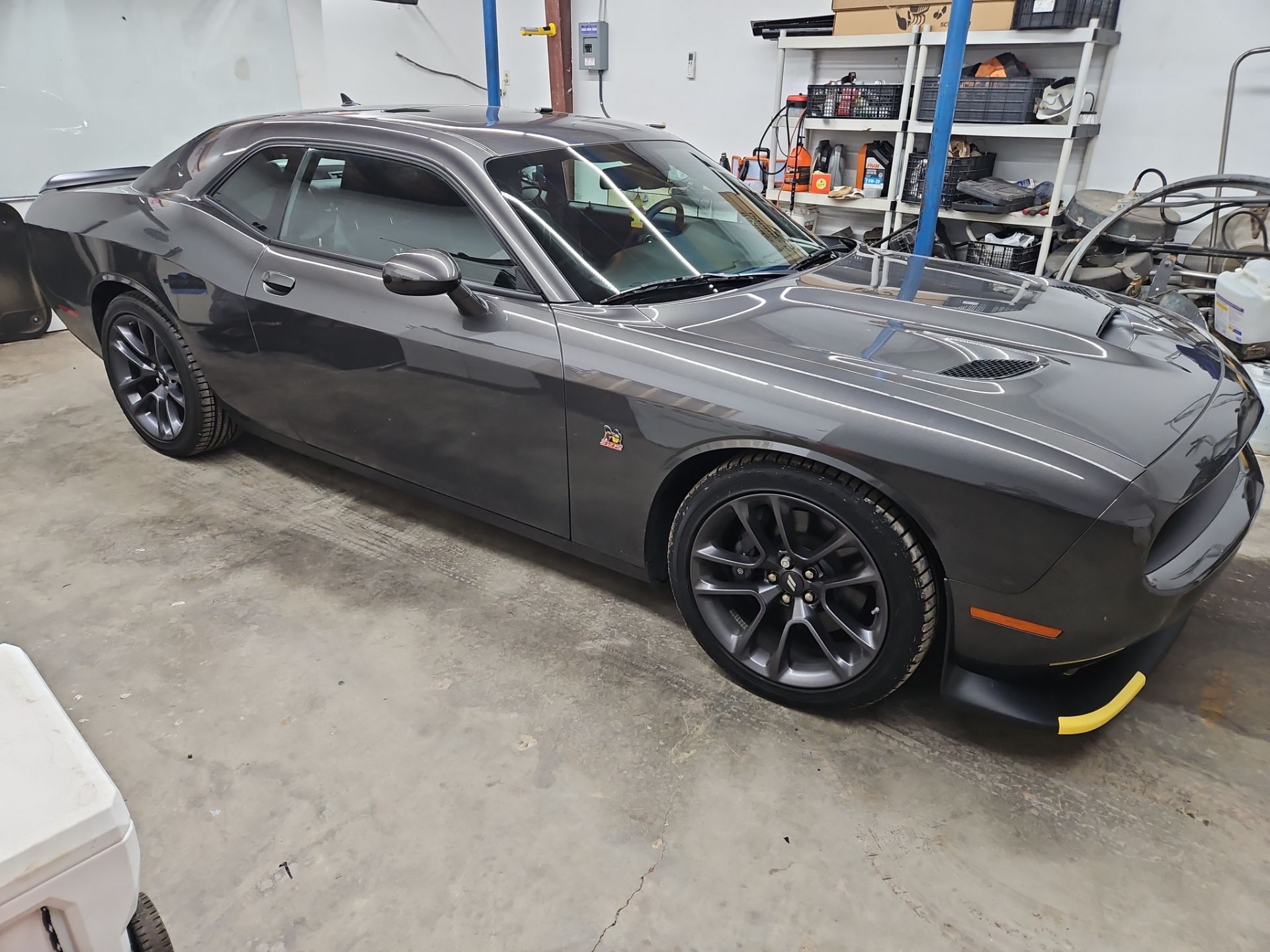 the service being done is the installation of window tint on a dark gray car likely a muscle car the tinting process involves applying a high-quality film to the windows to reduce heat and glare while enhancing privacy and aesthetics the car is positioned in a workshop indicating that the team at t's window tinting is taking care to ensure a professional finish the vehicle appears to have clean lines and a sporty look making the tinting a fitting enhancement