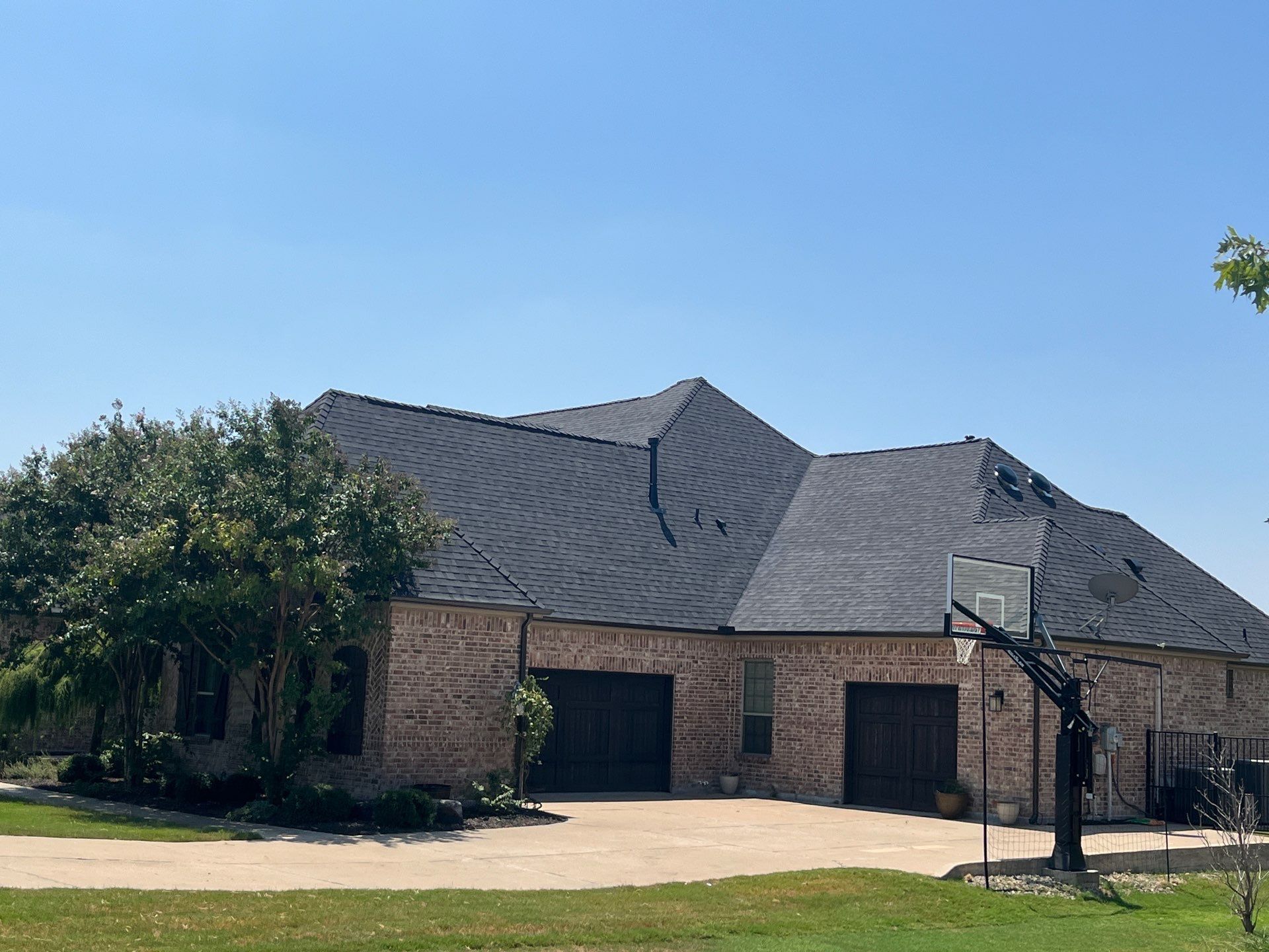 IKO Granite Black-Light Brown with dark brown sections brick house  by Tejas Roofworks + Restoration