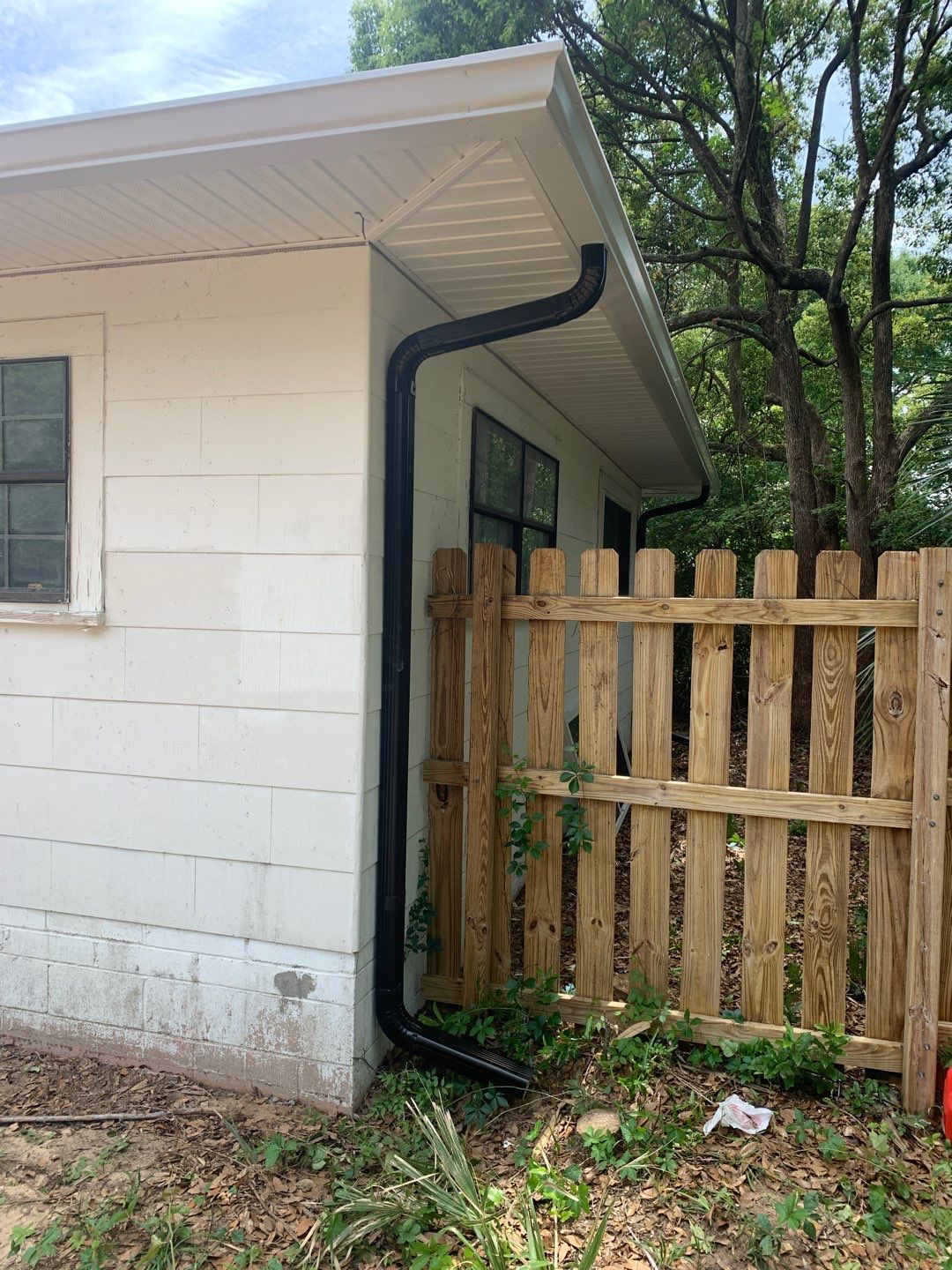 White Seamless Gutters and Black Downspouts by Gutter Professors
