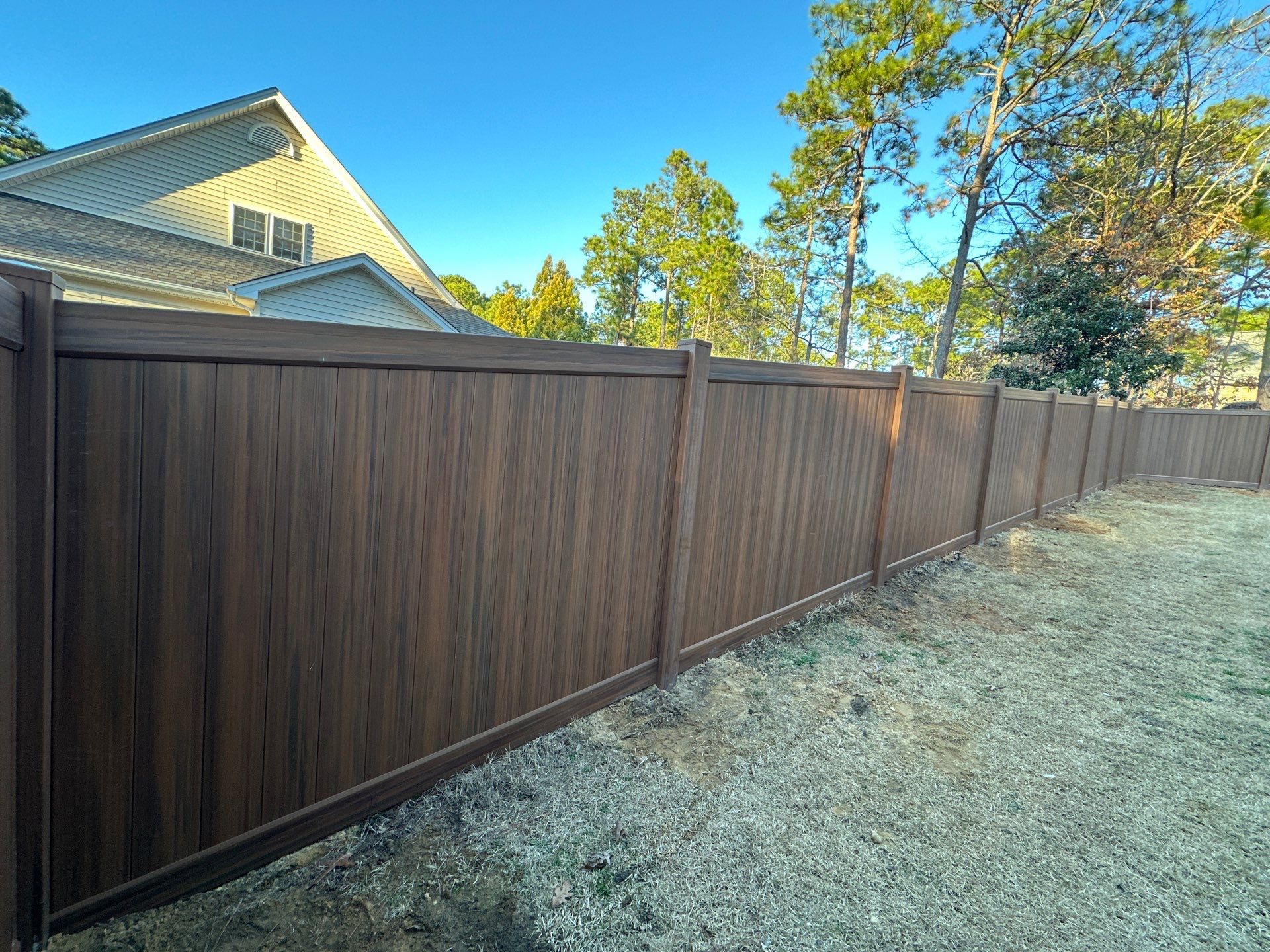 Mocha Walnut Wood-Grain Vinyl Privacy Fence Installation in Southern Pines by Superior Fence and Rail