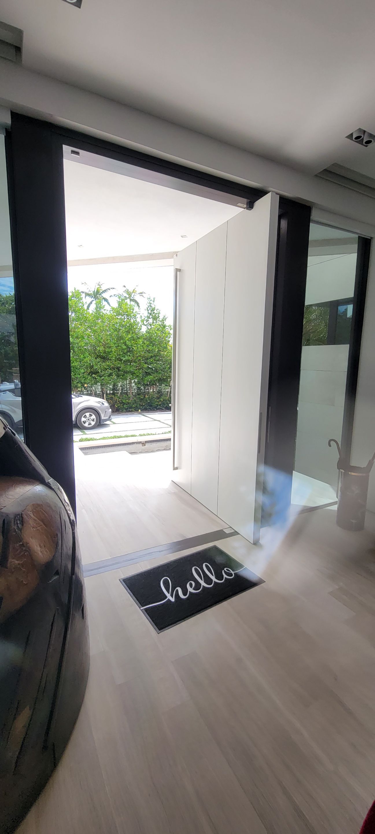 Custom Material Pivot Door installation by Impact Precious Wood Inc.