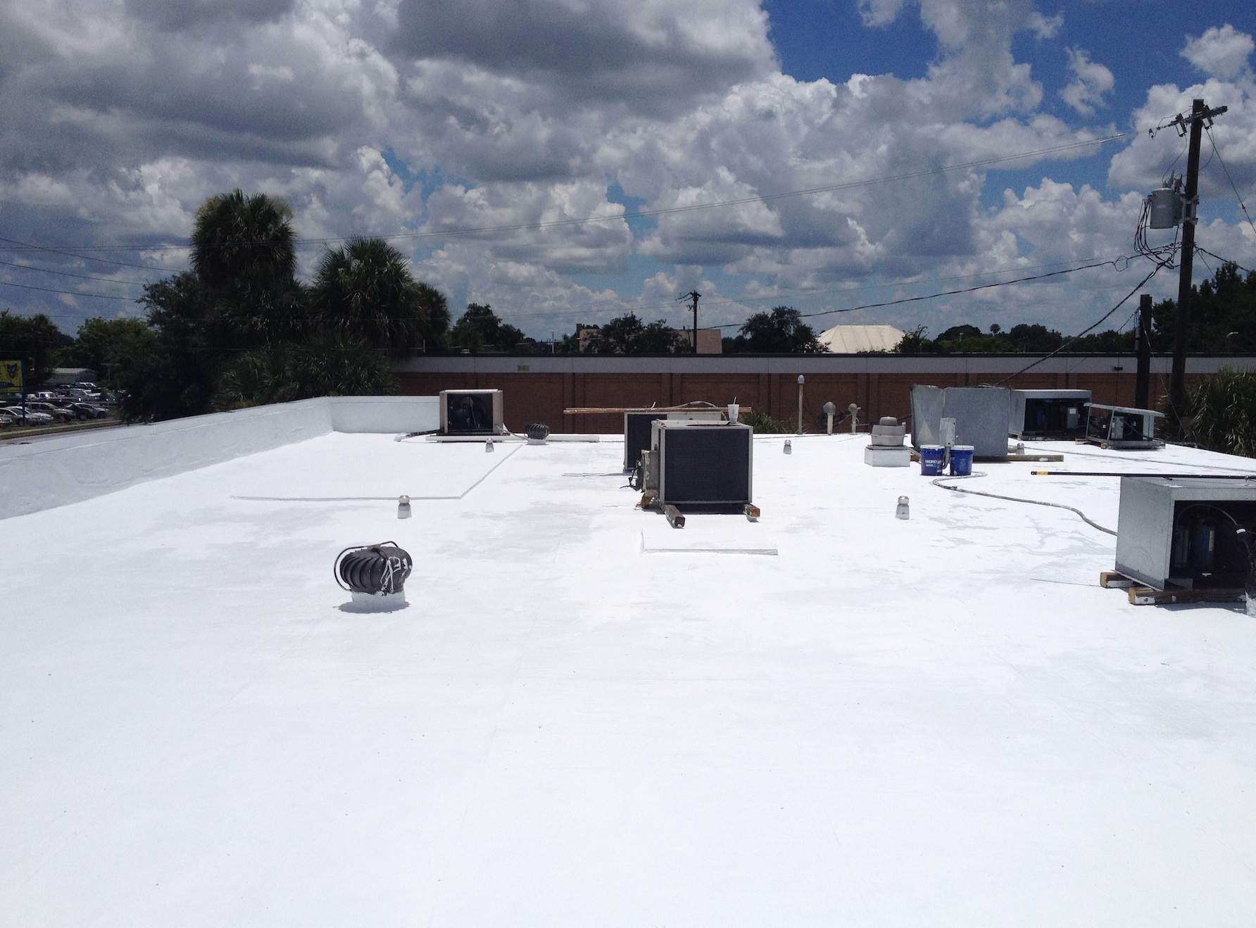 White Reflective Commercial Roof Coating Installation in Melbourne FL by Florida Roofing and Renovations Inc.