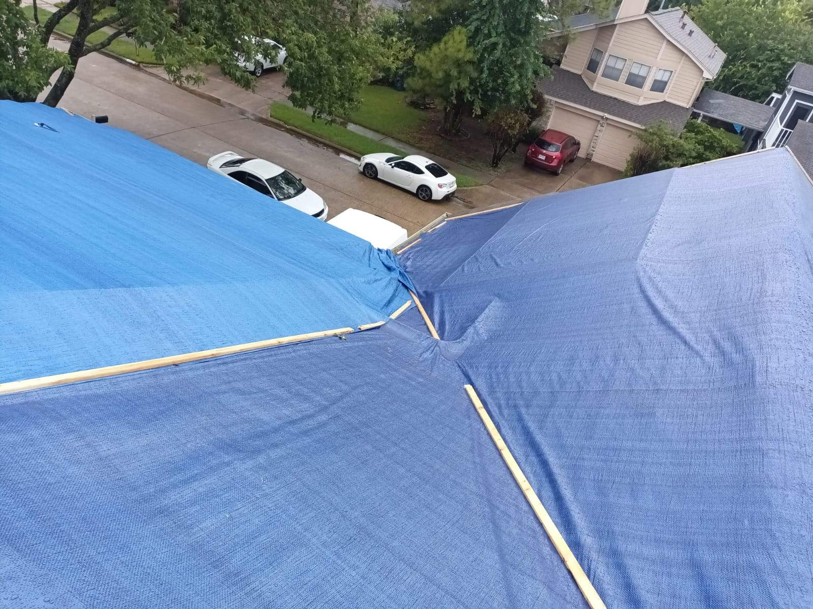 Placement of tarps on the roof. using TARP BLUE by V General Contractors 