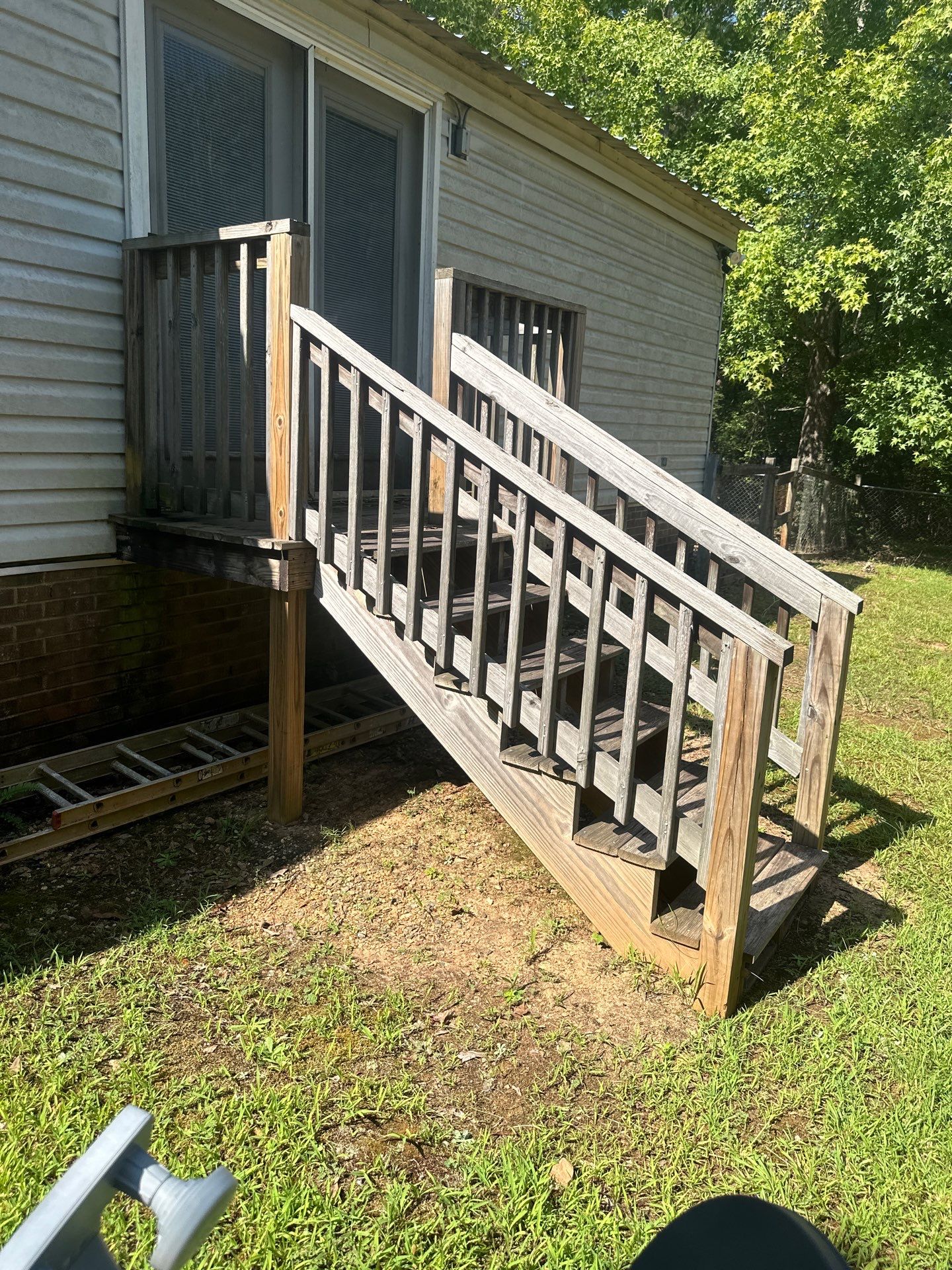 the service shown is cleaning and restoring a wooden deck and stairs using pressure washing techniques to remove dirt and grime