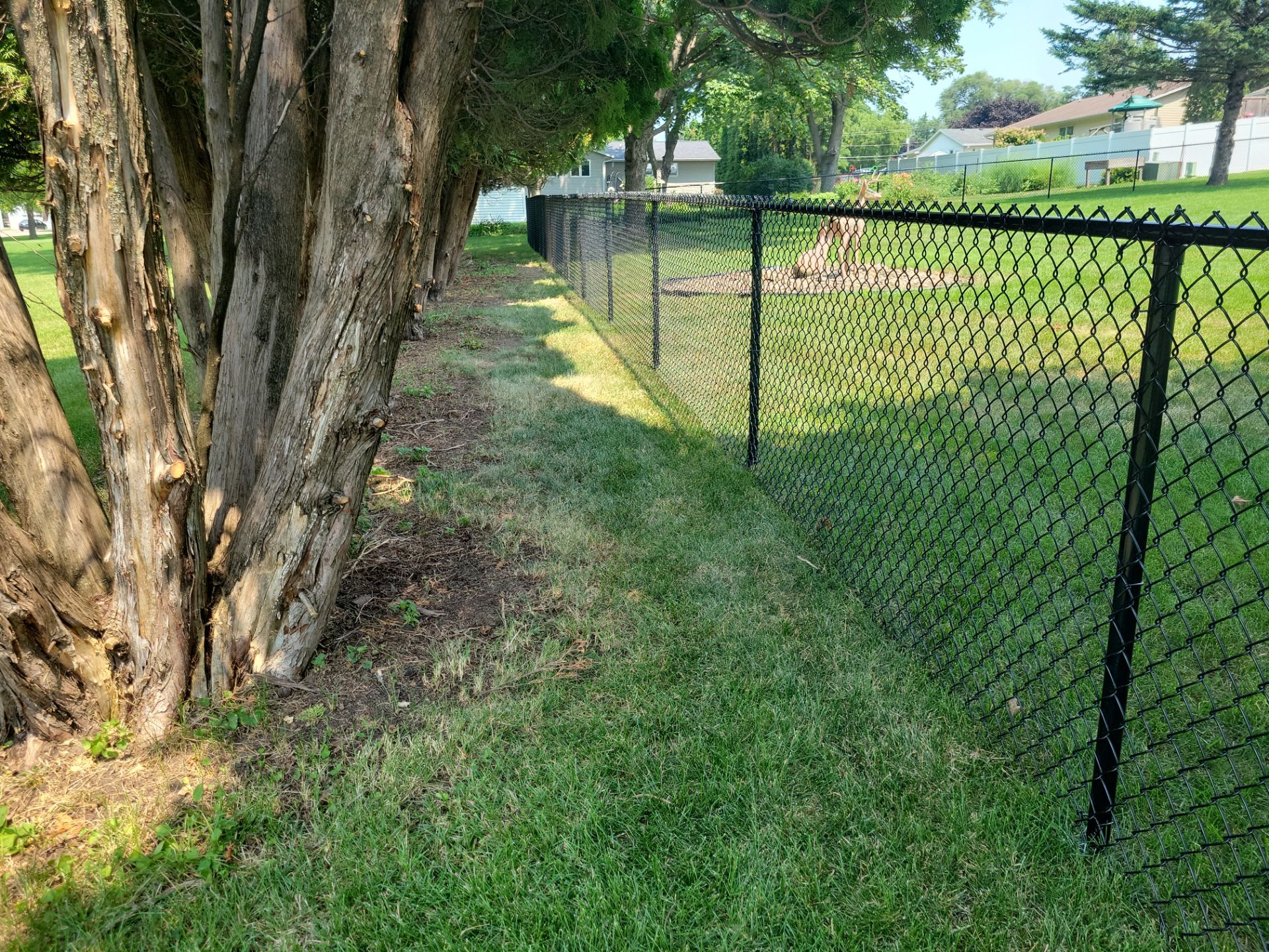 Black Vinyl-Coated Chain Link Fence Installation in New Hampton by Perfect Picket Fence and Stain