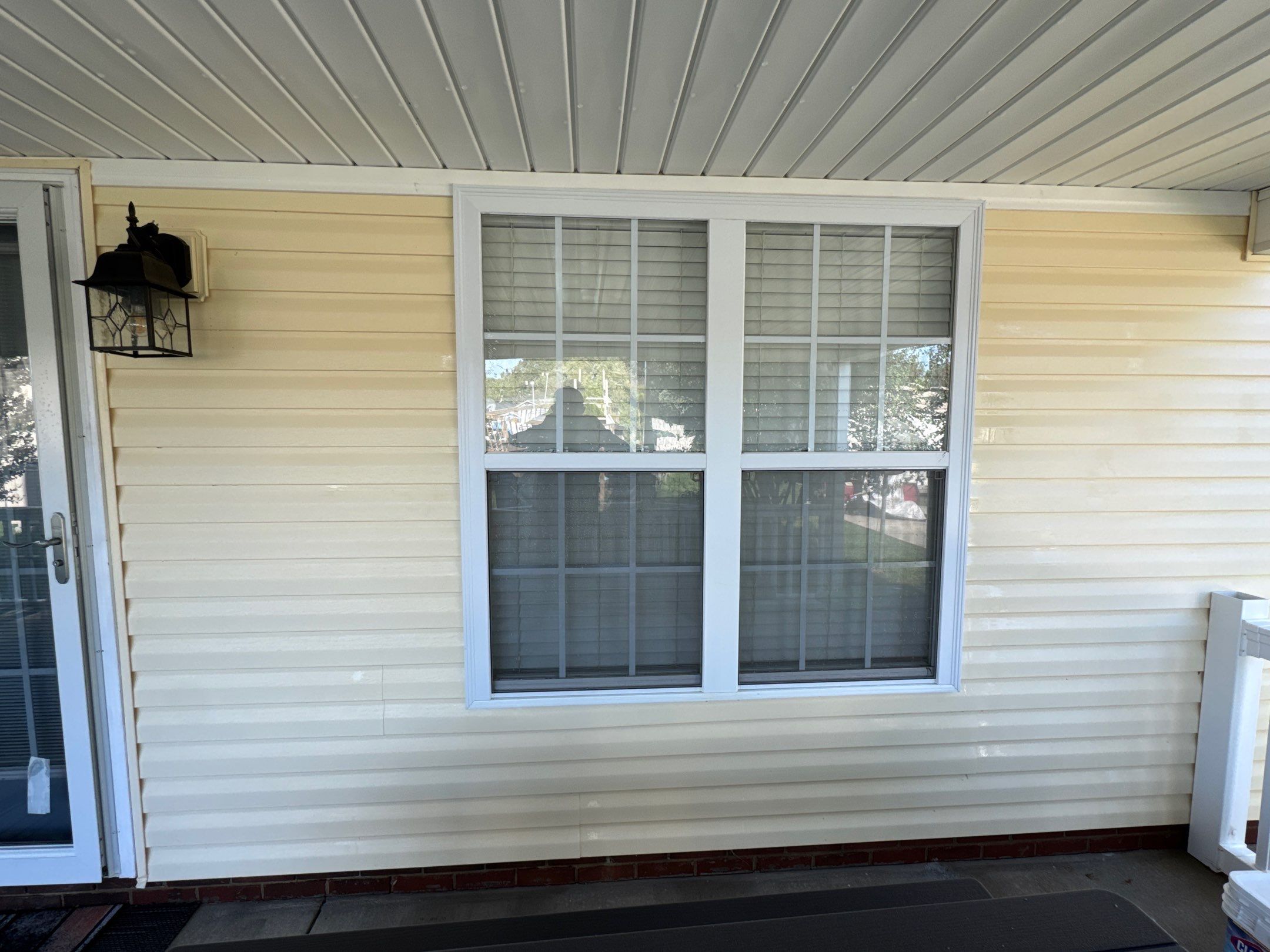 cleaning of vinyl siding and window trim with pressure washing techniques to remove dirt and restore appearance