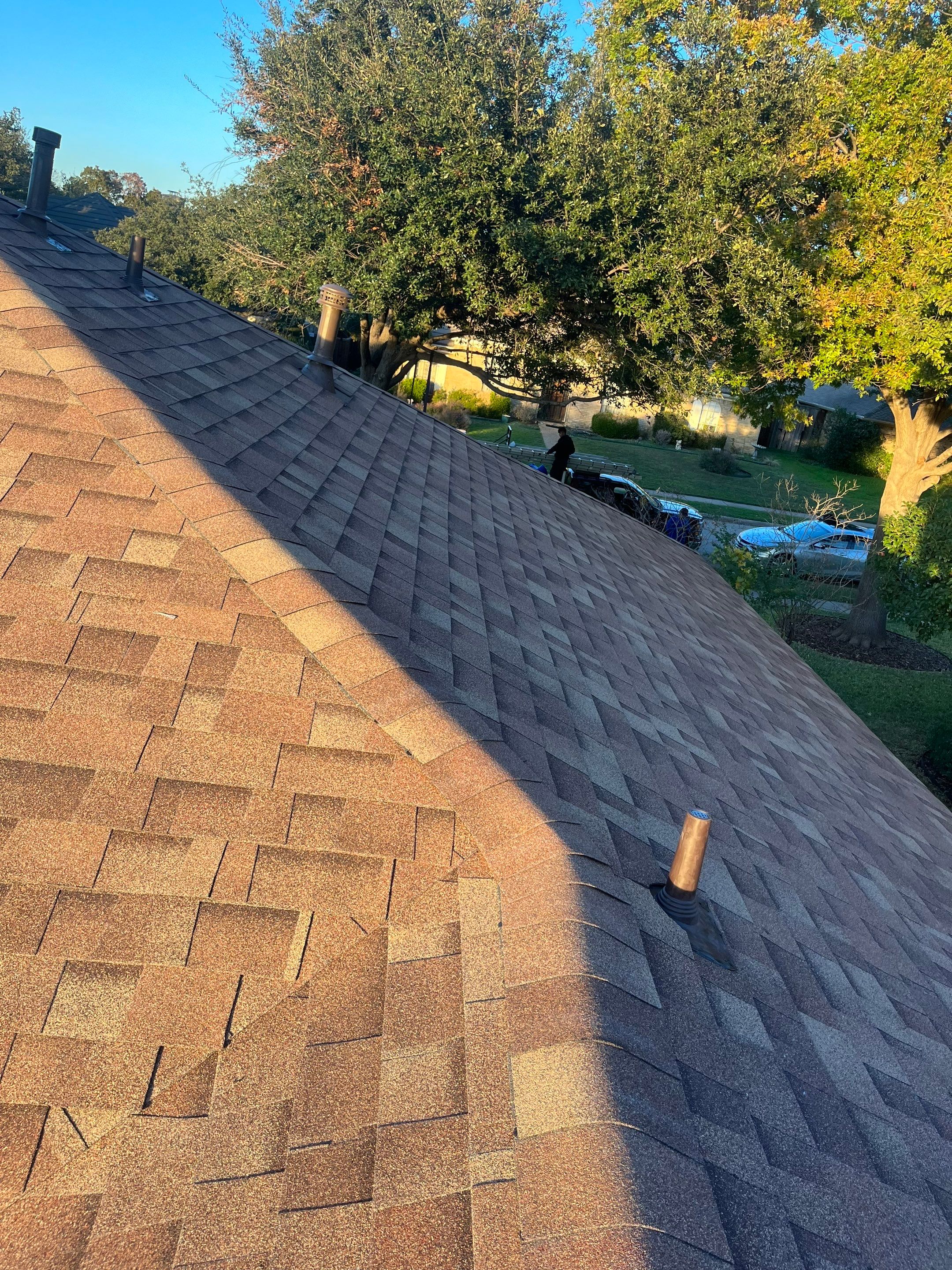 Brick with white area around windows with Malarkey Sienna Blend by Tejas Roofworks + Restoration