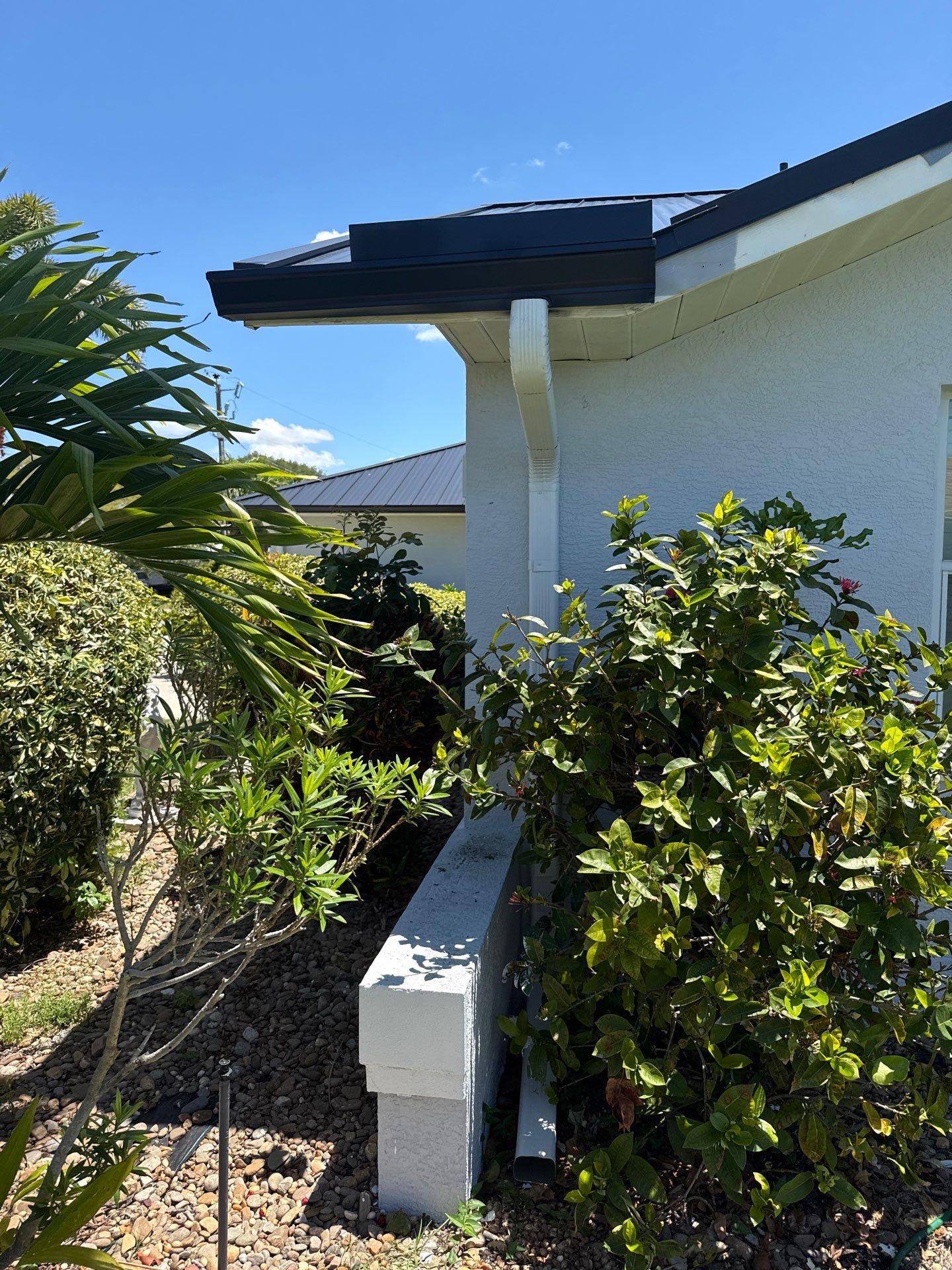 Black Seamless Gutters and White Downspouts in Cape Coral FL by Gutter Professors