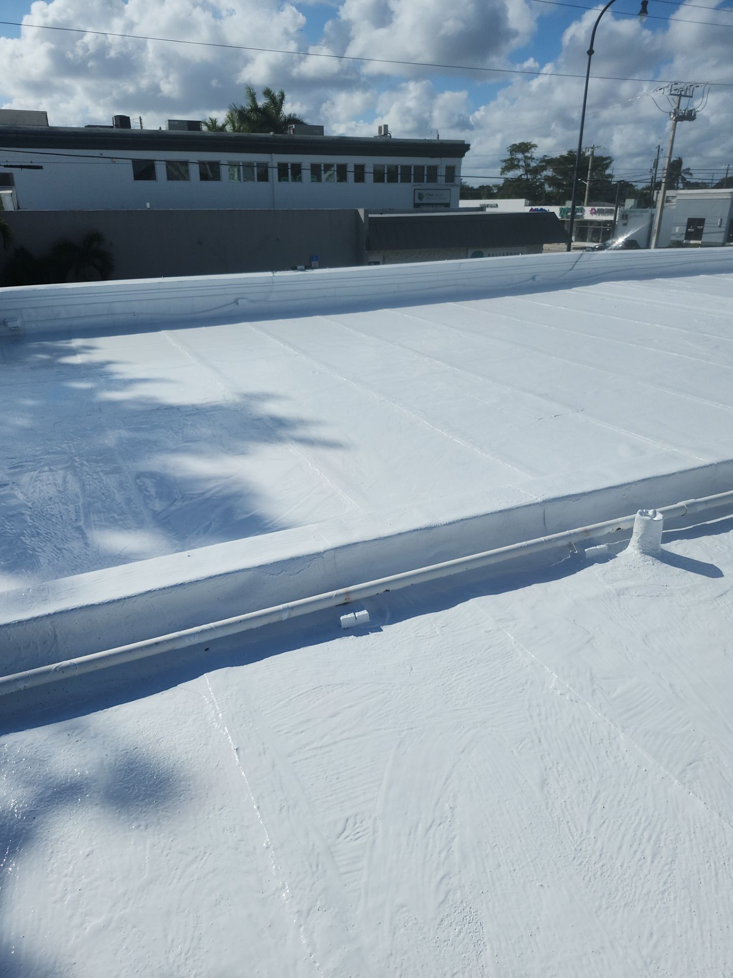 Commercial Flat Roof Restoration Using Silicone Coating in Hallandale Beach by Aastro Roofing