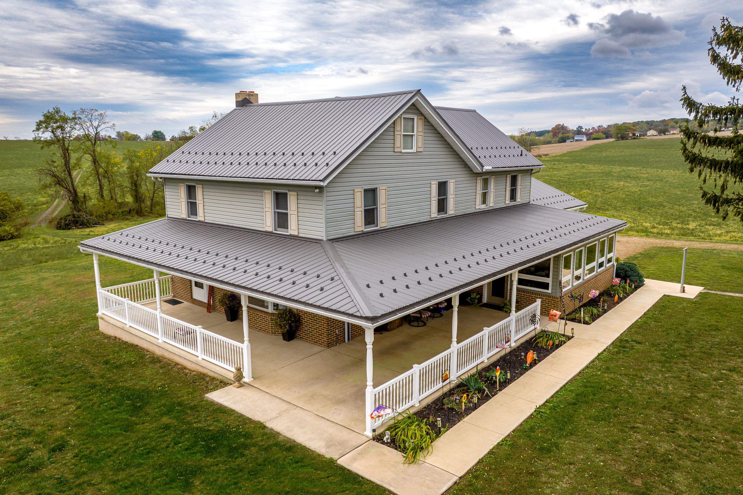 Classic Farmhouse With Textured Charcoal Metal Roof by Esh Builders