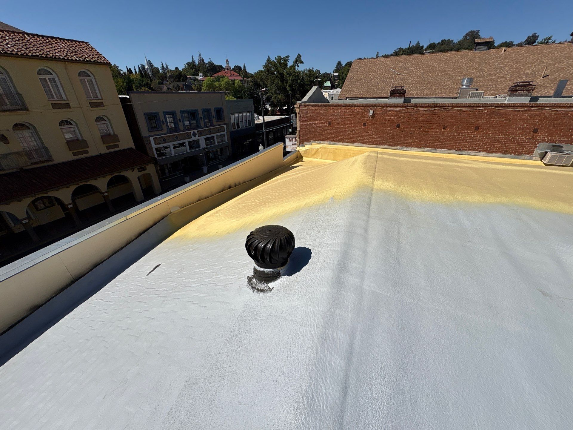Foam and coatings on commercial roof by Straight Edge Roofing Inc