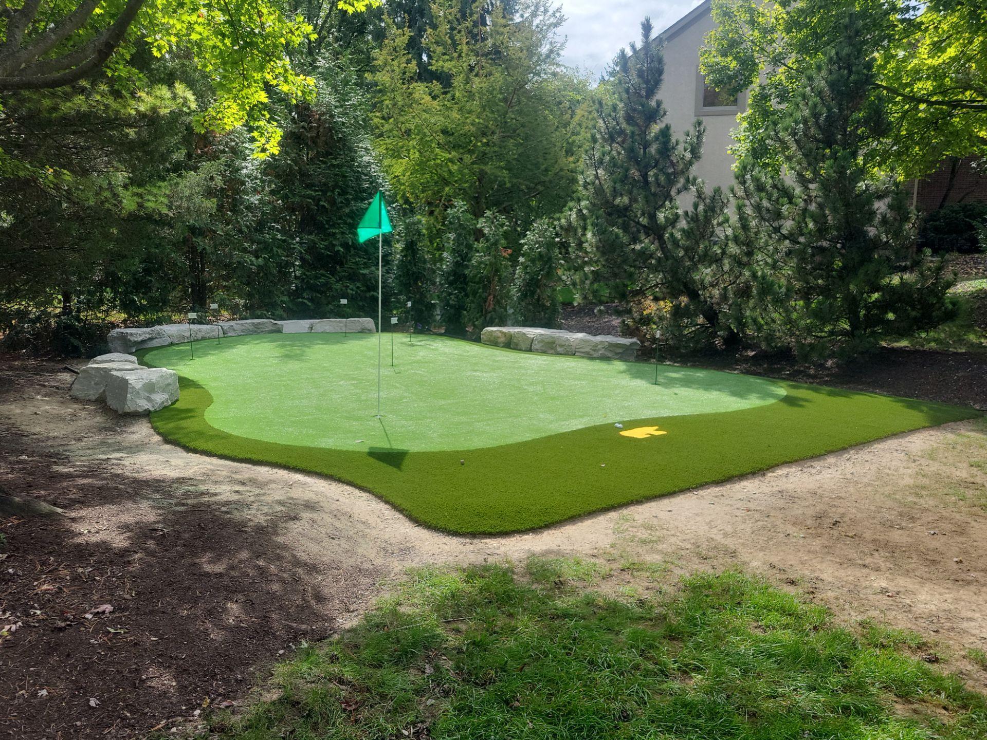Custom Backyard Putting Green around Landscape Boulders in Hilliard by Southwest Greens Midwest