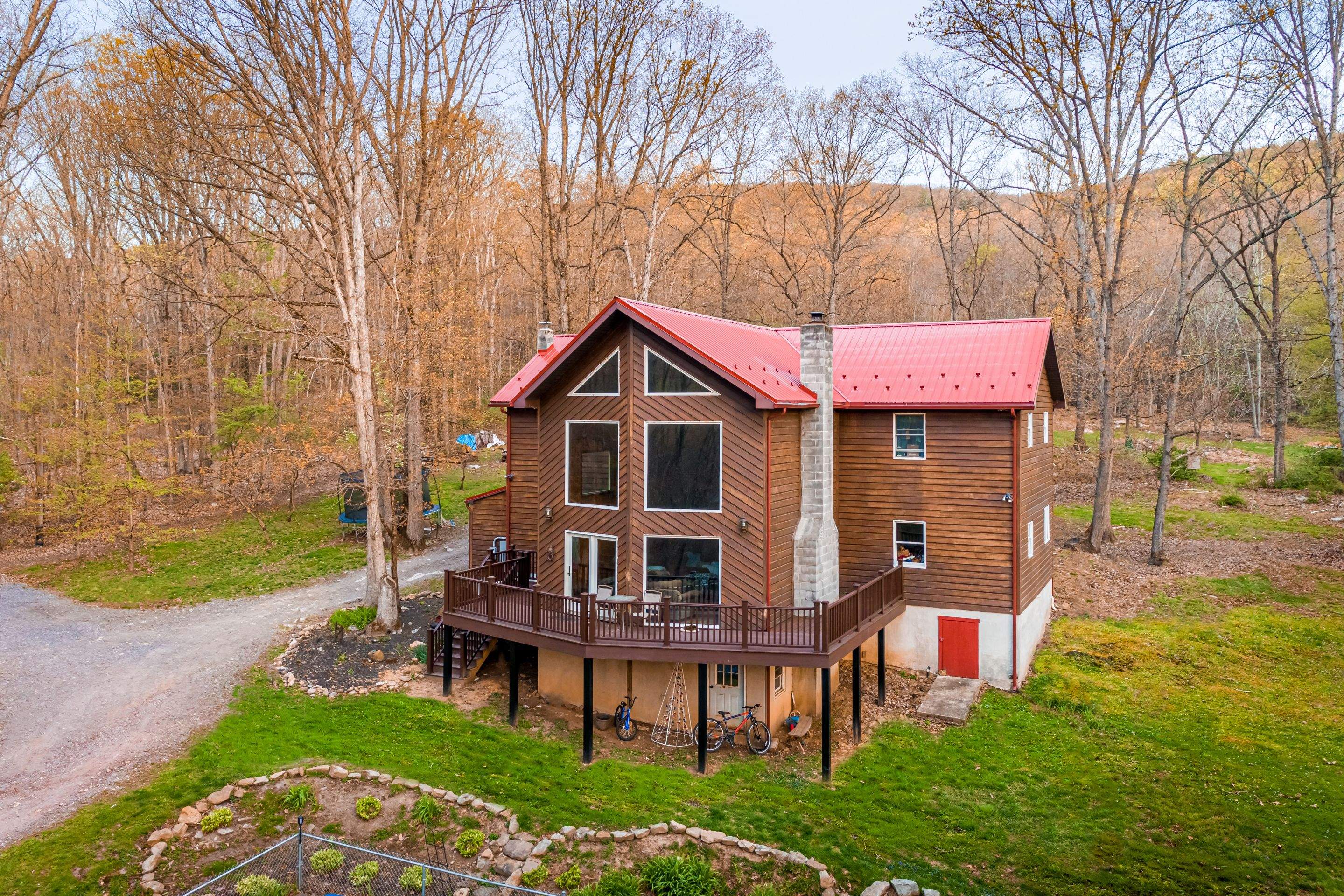 Metal Roof-barn red and new deck by Esh Builders